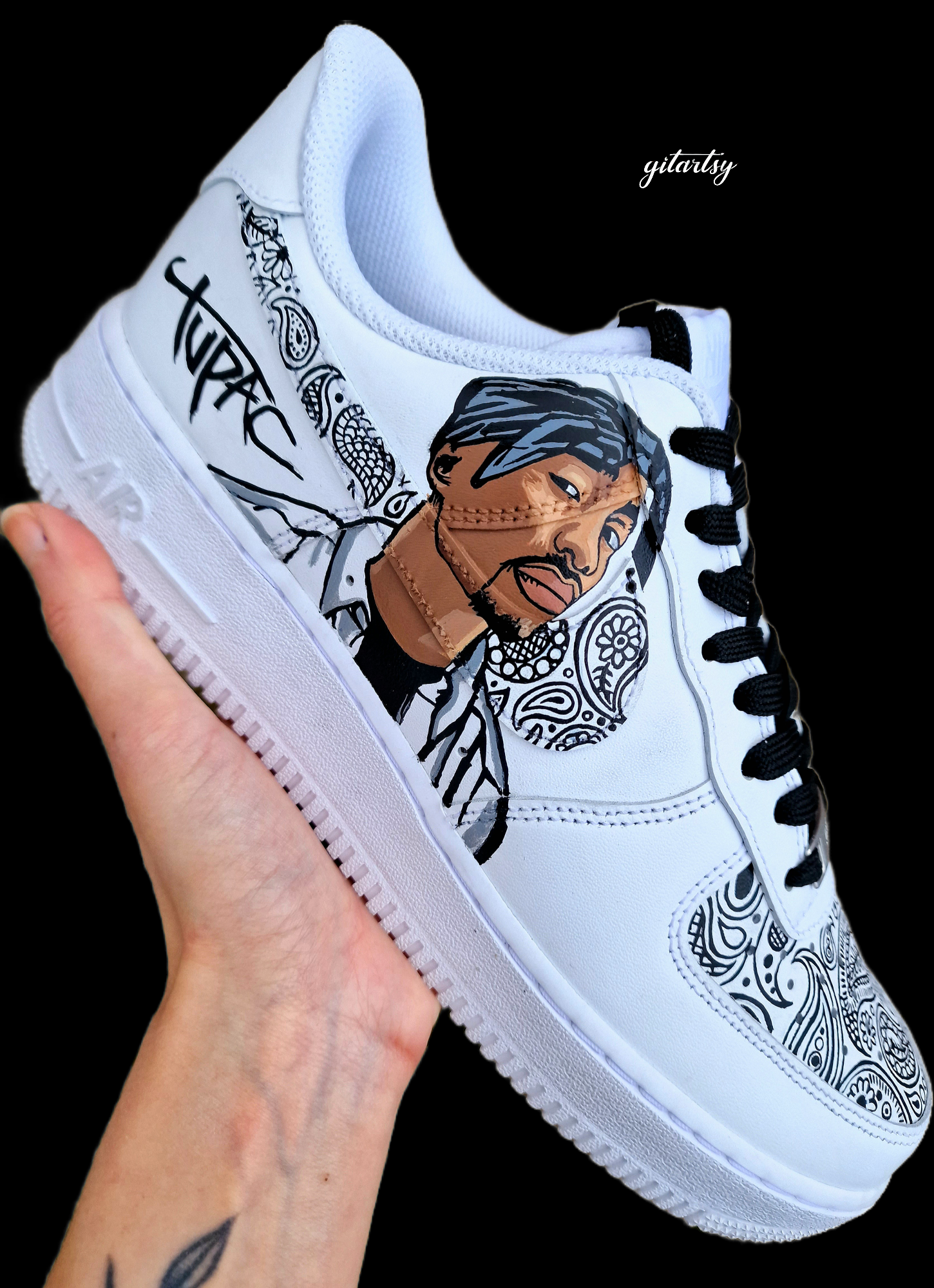 Custom hand-painted Nike Air Force 1 sneakers featuring Sidhu Moosewala’s kara and hand artwork, realistic portrait of Tupac, and intricate Indian paisley leaf patterns. A tribute to legendary singers, painted on white leather sneakers with waterproof durable finish.