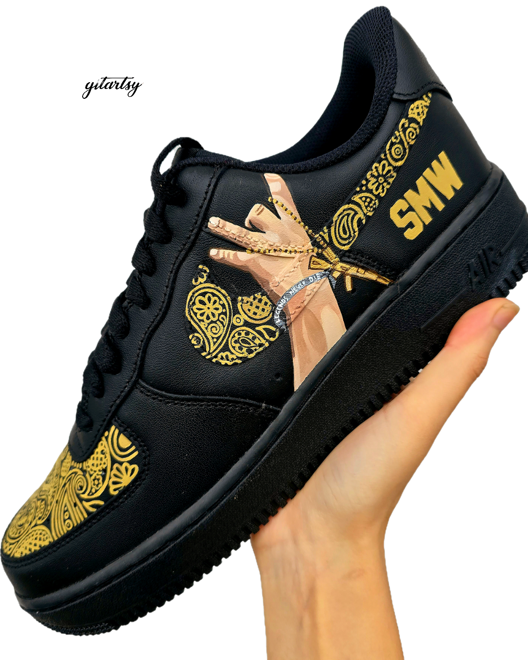 Custom black Nike Air Force 1 sneakers featuring detailed hand-painted artwork including a realistic portrait of Sidhu Moosewala on one side, and a lifelike hand wearing a silver kara and gold jewelry on the other, surrounded by intricate golden Punjabi patterns with bold text that reads “LEGEND” and “SMW”, designed by Gitartsy.