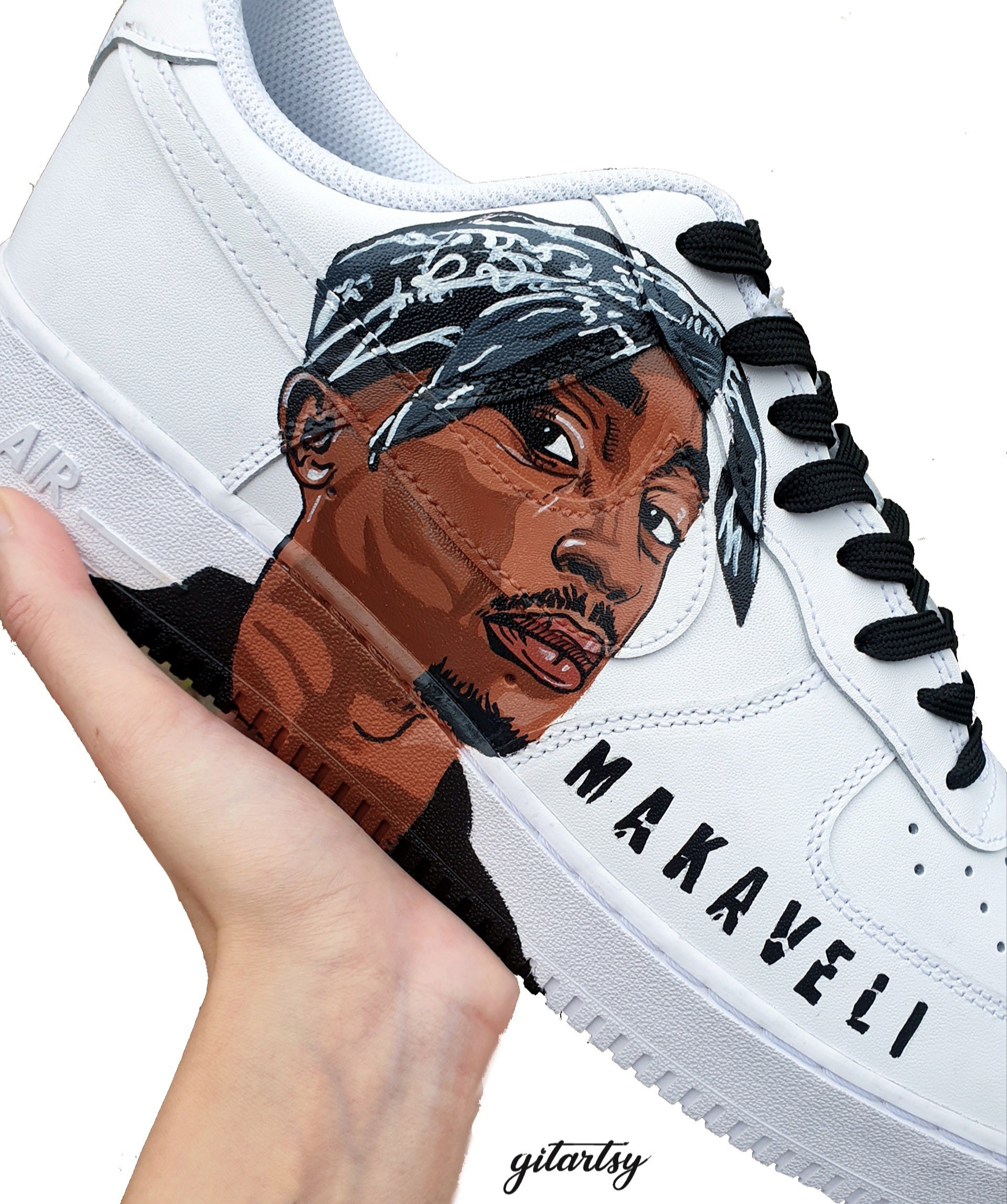Custom hand-painted Nike Air Force 1 sneakers featuring vivid portraits of Tupac Shakur and The Notorious B.I.G. Designed by Gitartsy, these one-of-a-kind sneakers highlight Tupac's "Makaveli" persona and Biggie’s classic lyric “It Was All A Dream,” detailed with waterproof paint on genuine leather. A bold fusion of streetwear and tribute art, perfect for collectors and hip-hop fans.