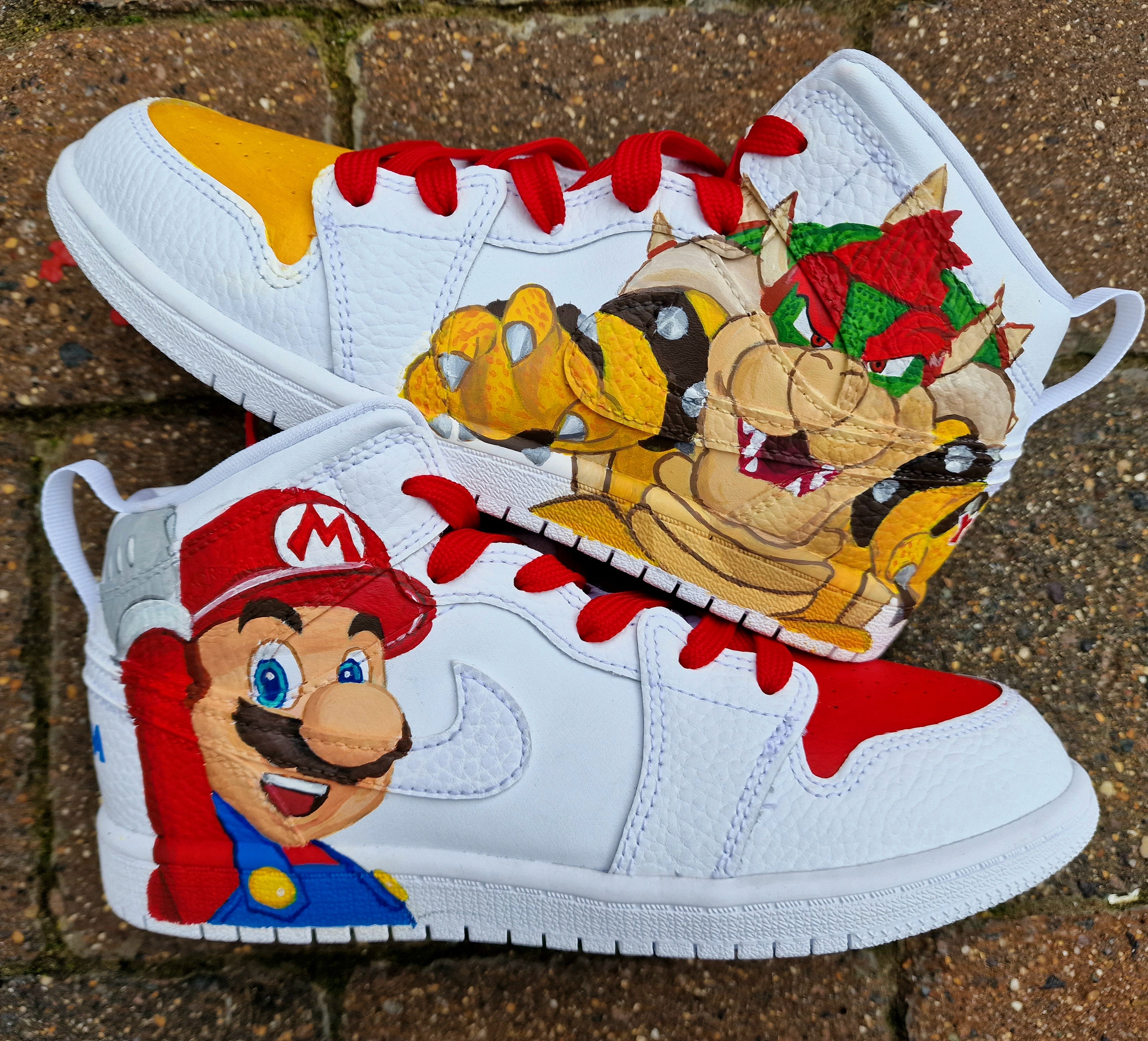 Hand-painted custom kids sneakers featuring vibrant Super Mario artwork with Mario and Bowser characters on a high-quality leather Jordan-style base, red and yellow detailing, and optional name customisation, created by Gitartsy.