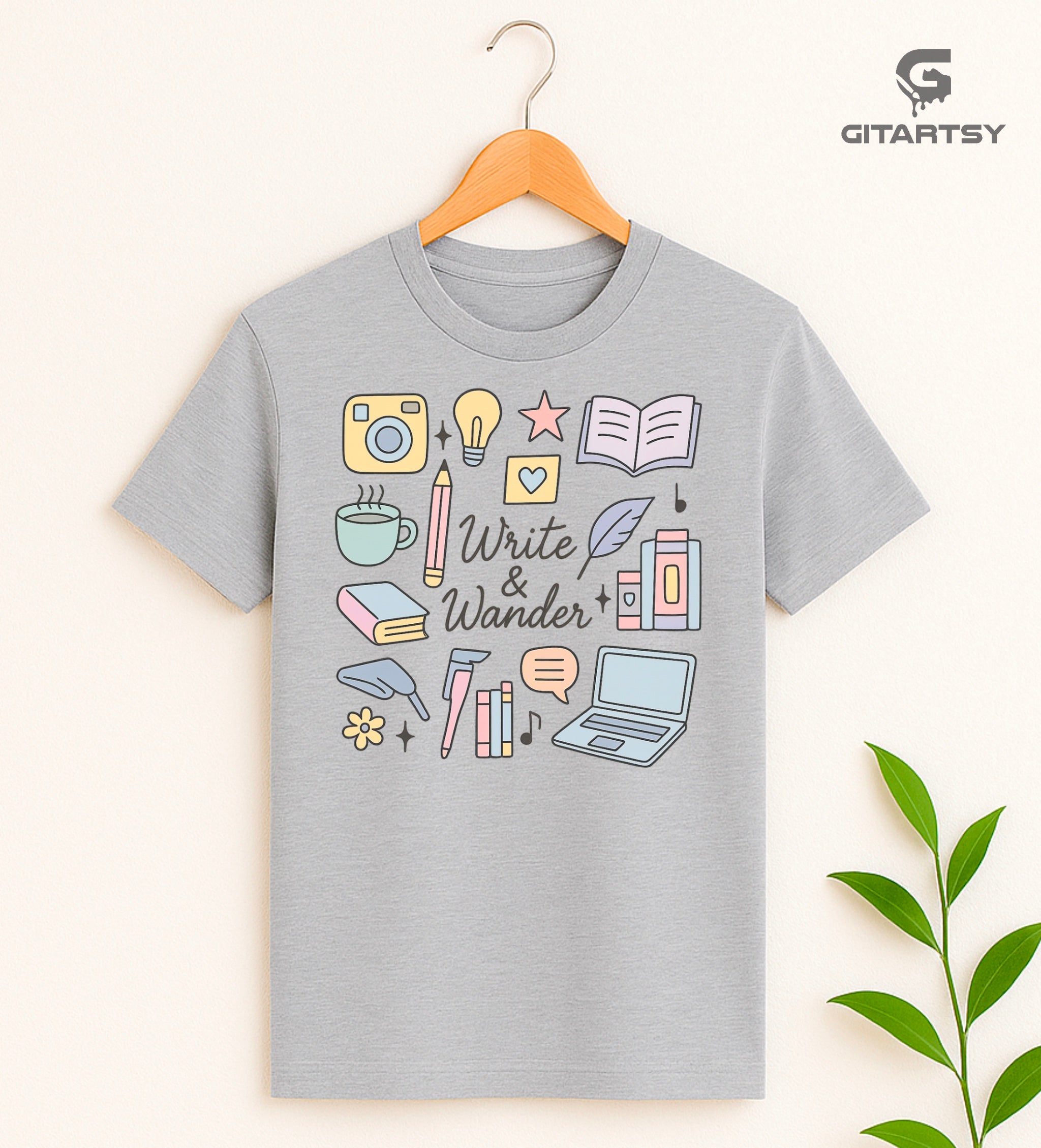 Pastel "Write & Wander" T-shirt featuring hand-drawn illustrations of books, coffee, laptop, pencil, camera, light bulb, and writing icons on a soft cotton fabric – ideal for writers, bloggers, and book lovers.