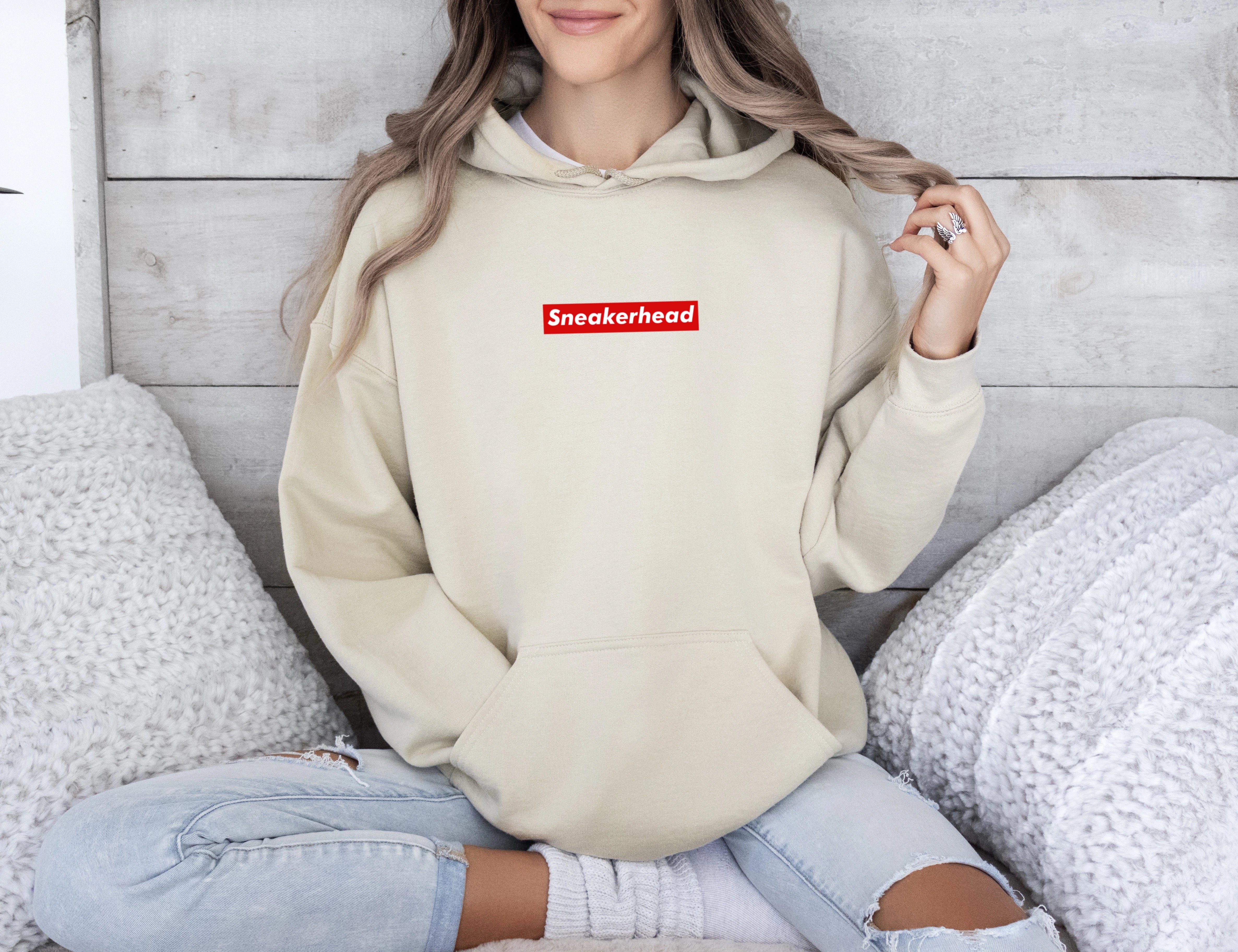 sneakerhead hoodie inspired by supreme with a sleek red rectangle design on a beige hoodie with the word sneakerhead written