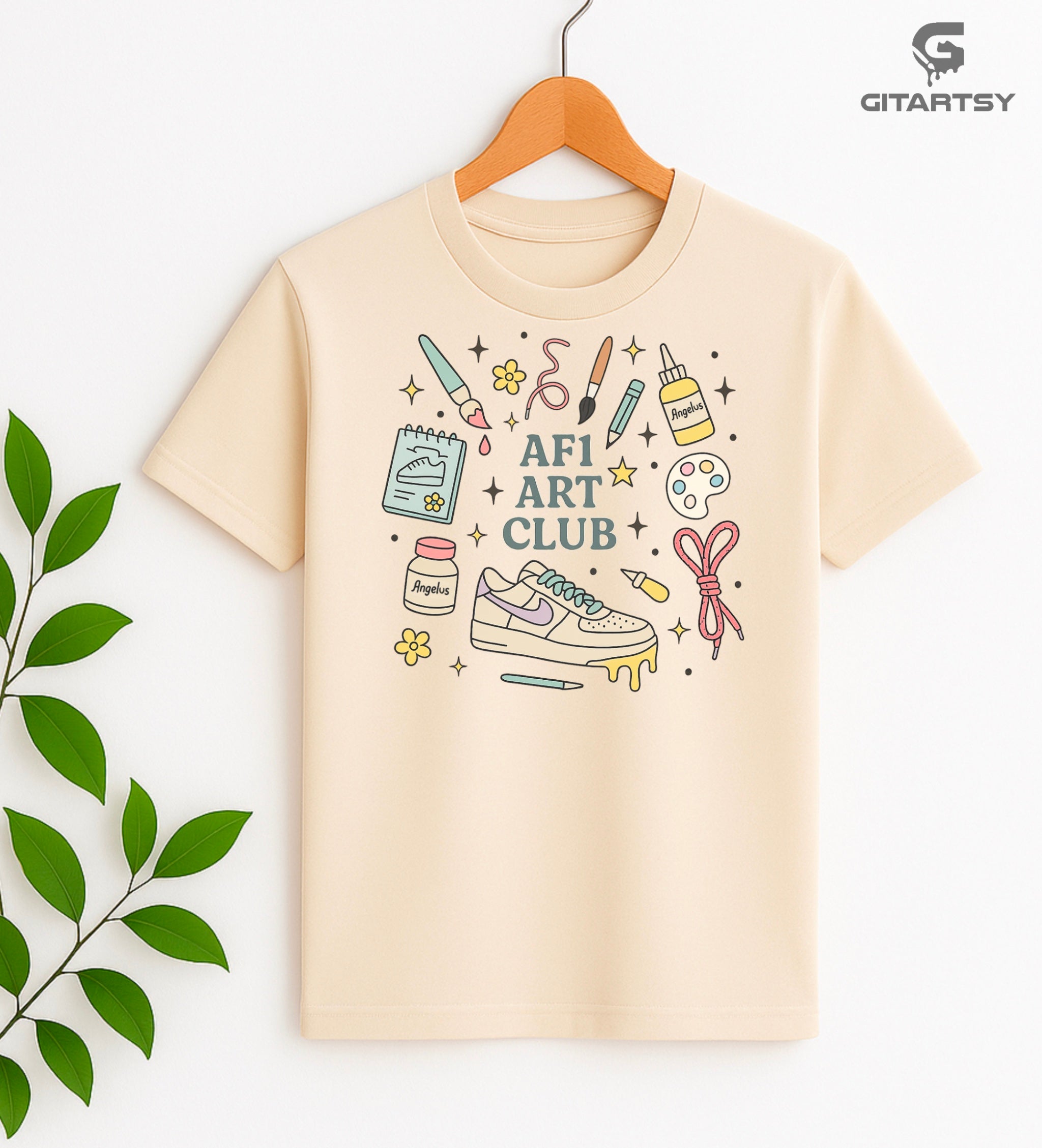 Pastel “AF1 Art Club” T-shirt featuring custom sneaker tools, Angelus paint bottles, laces, and AF1 art illustrations – perfect for shoe customisers and sneaker artists.