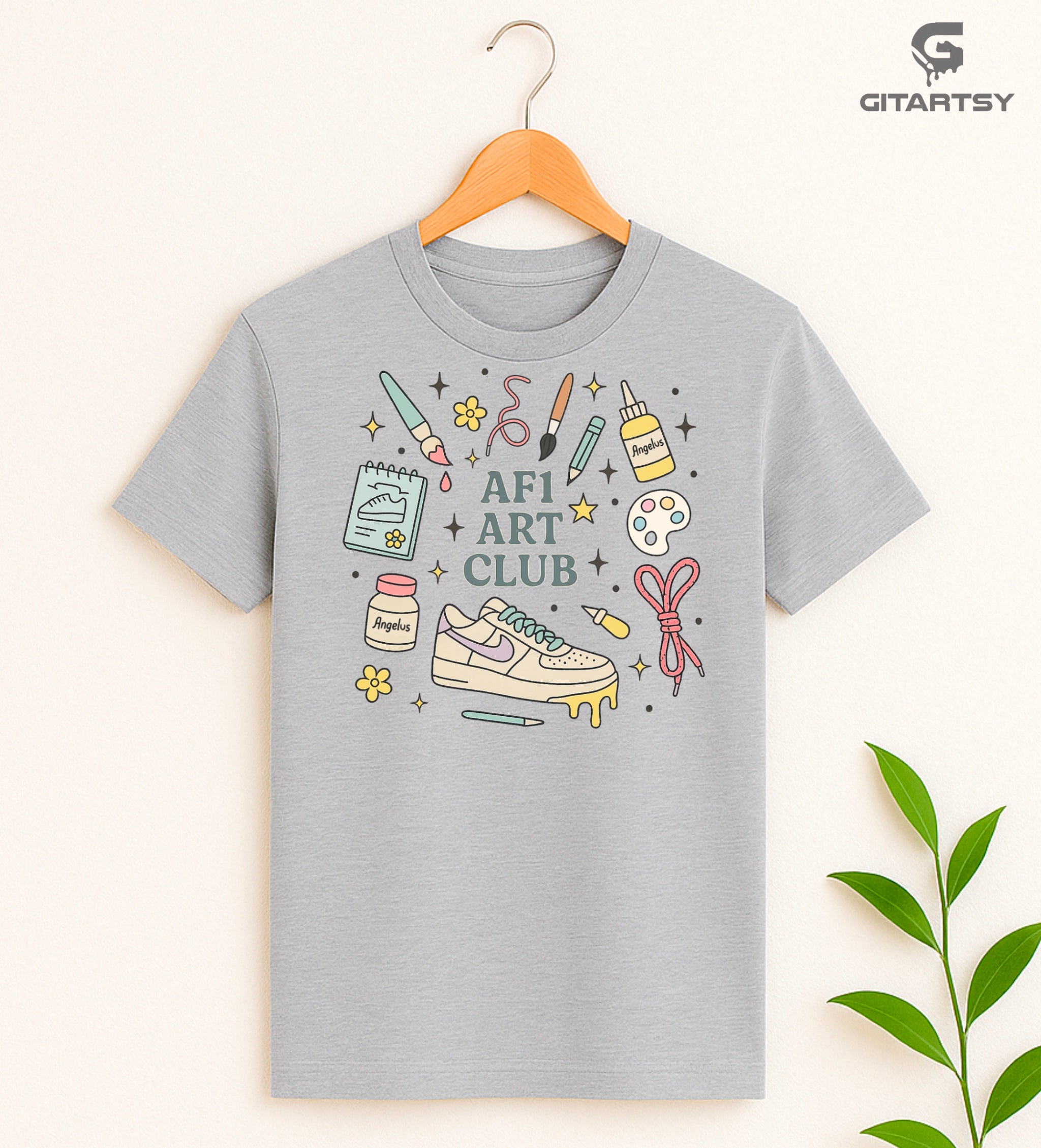 Pastel “AF1 Art Club” T-shirt featuring custom sneaker tools, Angelus paint bottles, laces, and AF1 art illustrations – perfect for shoe customisers and sneaker artists.