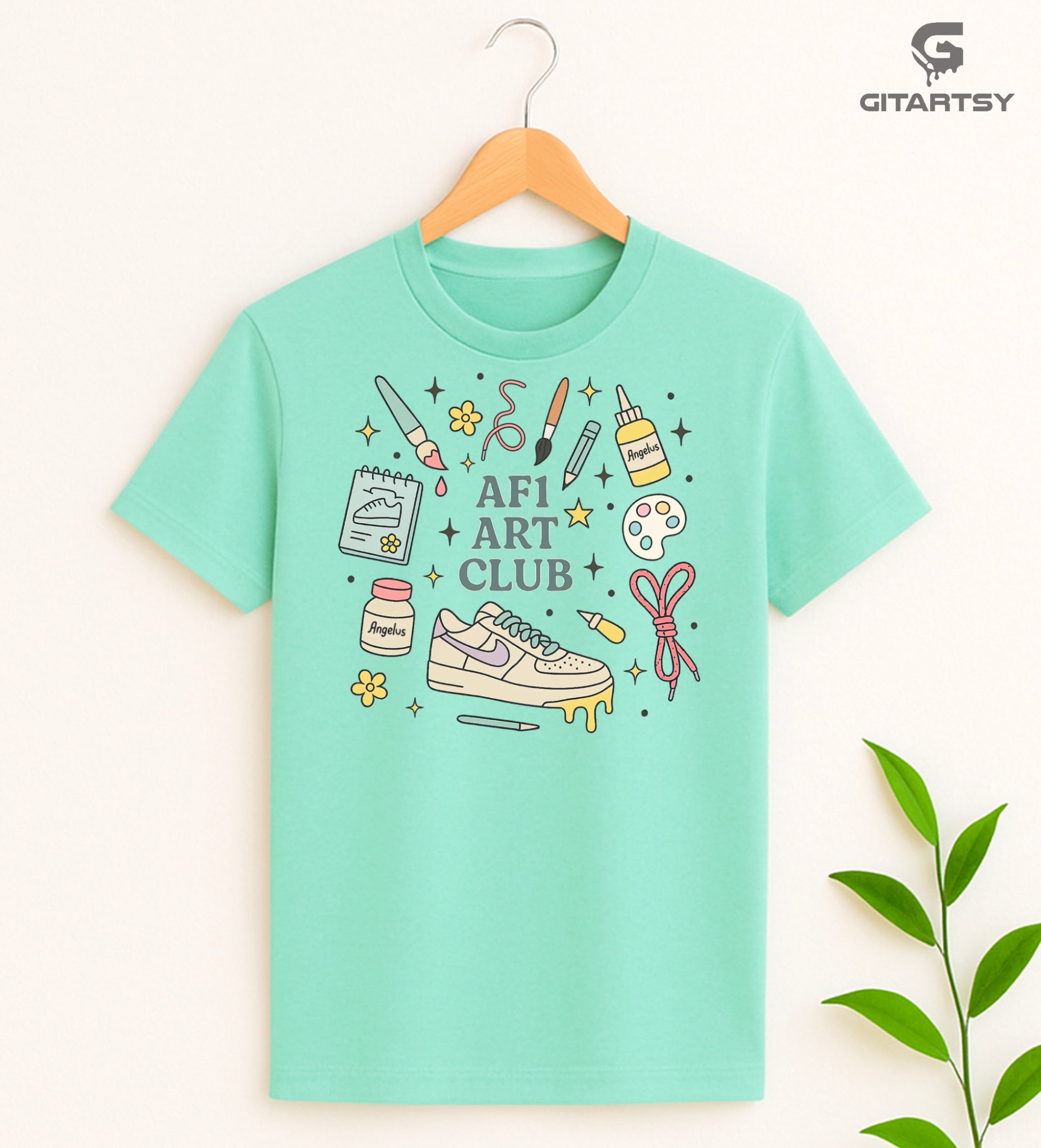 Pastel “AF1 Art Club” T-shirt featuring custom sneaker tools, Angelus paint bottles, laces, and AF1 art illustrations – perfect for shoe customisers and sneaker artists.