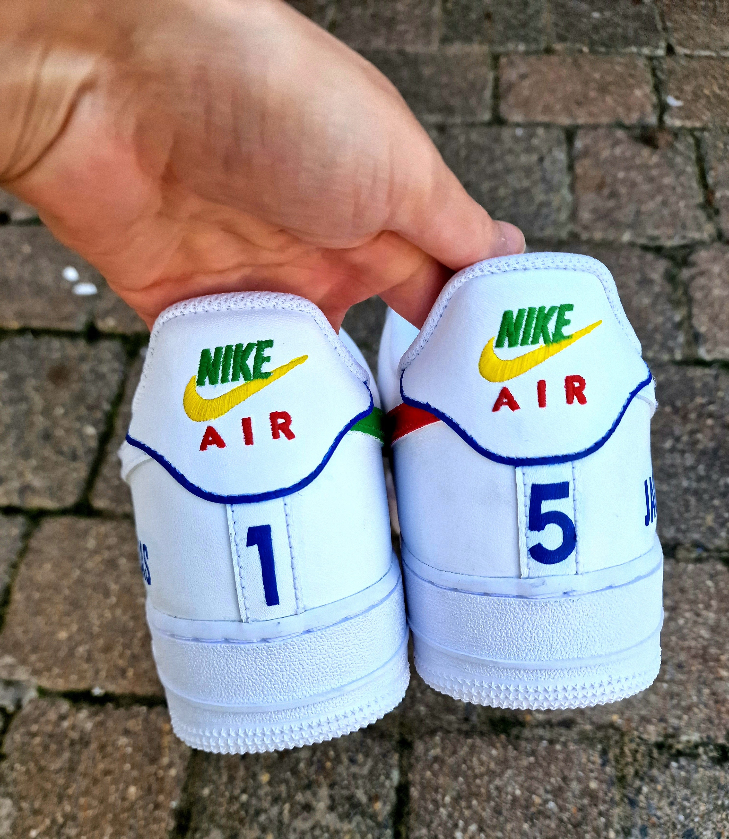 Custom Adolfinho Brazil-inspired Nike Air Force 1 sneakers featuring hand-painted green, yellow, and blue drip art, football graphics, the player name Adolfinho, the number 22, custom strap text, and vivid laces; unique wearable streetwear art designed for football fans and sneaker collectors who want personalised, one-of-a-kind kicks that celebrate Brazilian sports culture.
