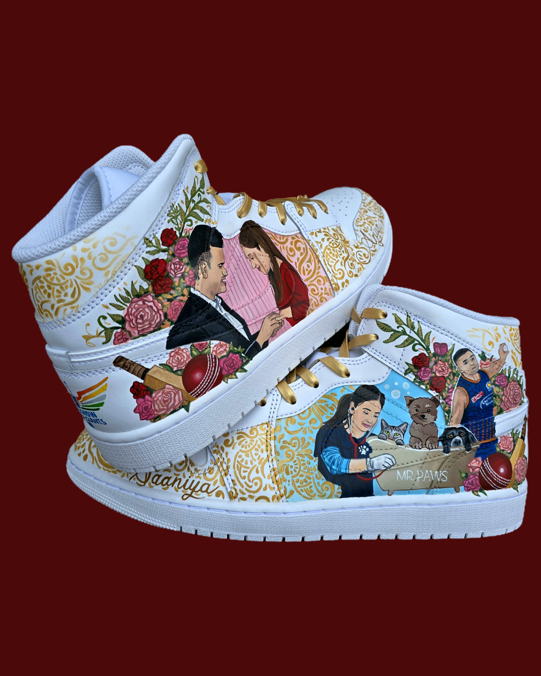 A pair of nike jordan 1 white high-top sneakers with custom illustrations of a couple Arjun Tendulkar and Saaniya Chandhok with gold paisley patterns henna, pets, florals with maroon and blue colour scheme displayed against a dark red background with a GITARTSY logo in the corner.