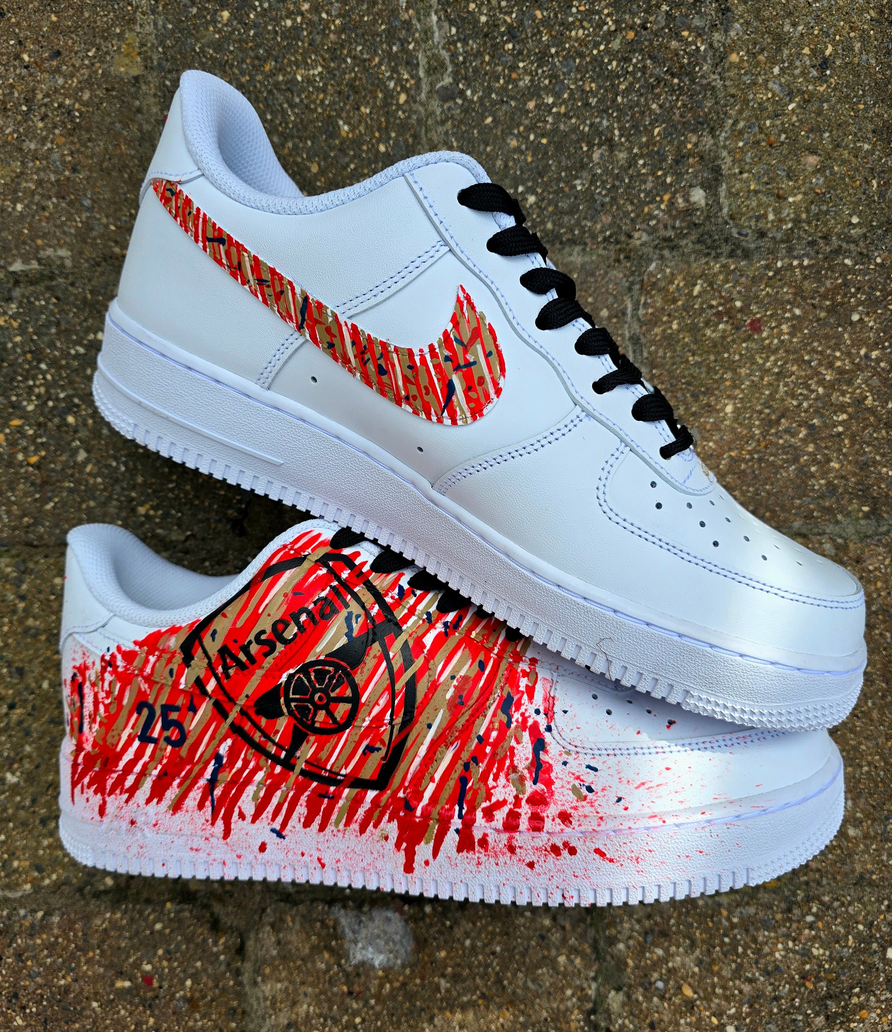 Custom hand-painted Nike Air Force 1 sneakers with Arsenal FC-inspired design, featuring red, gold, and navy brush strokes, personalized details like player name and number, Arsenal logo, and splatter effect art—crafted on a genuine white leather Nike AF1 base by Gitartsy.

