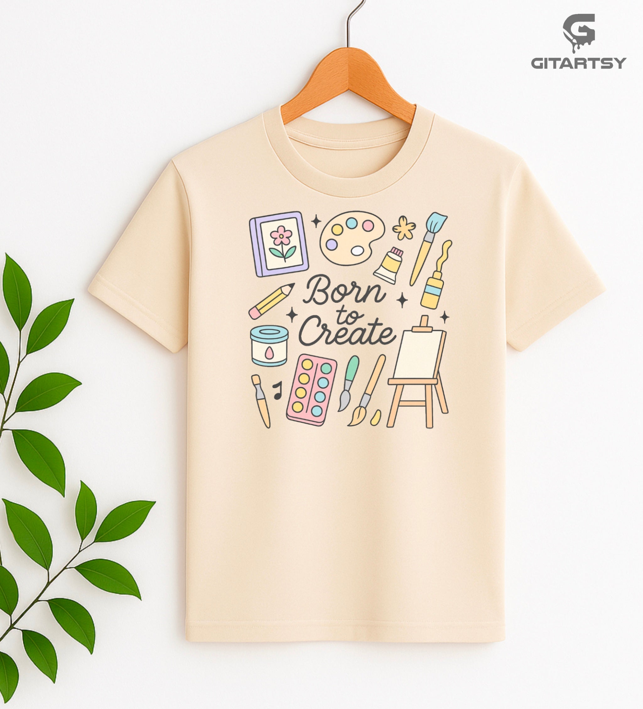 "Born to Create" pastel art T-shirt for fine artists with doodles of brushes, easel, paint tubes, and creative tools on a cotton tee