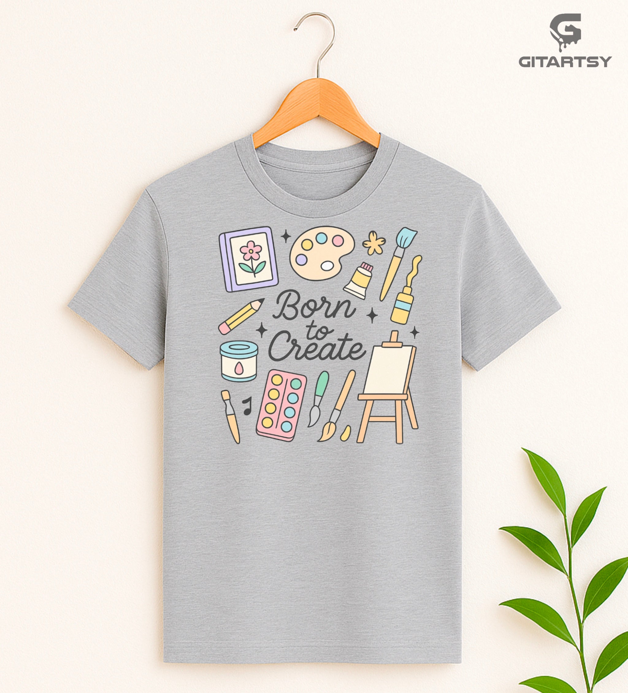 "Born to Create" pastel art T-shirt for fine artists with doodles of brushes, easel, paint tubes, and creative tools on a cotton tee
