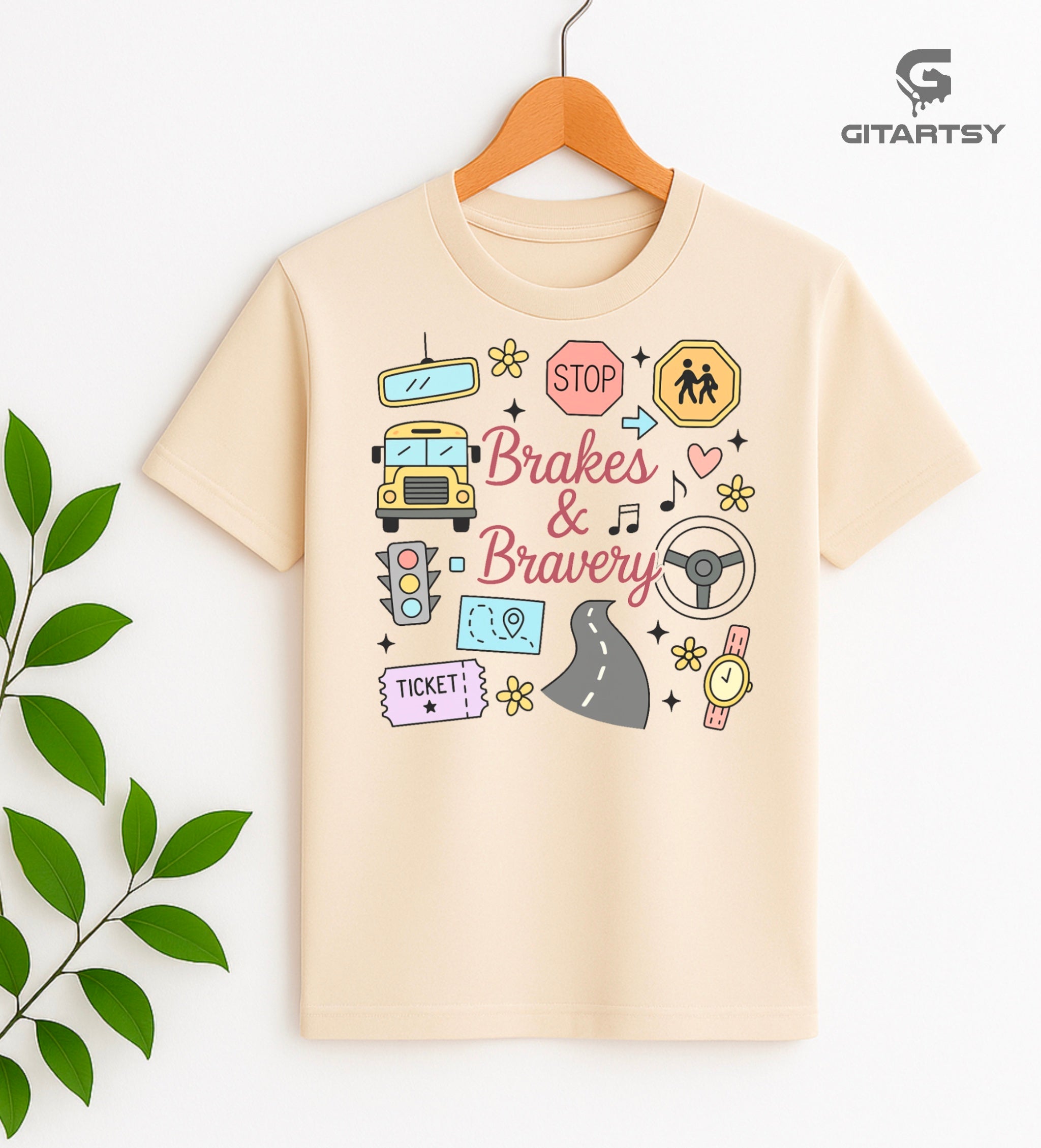Pastel T-shirt with “Brakes & Bravery” design featuring illustrated school bus, road signs, steering wheel, and driving elements – ideal gift for bus drivers and transport staff