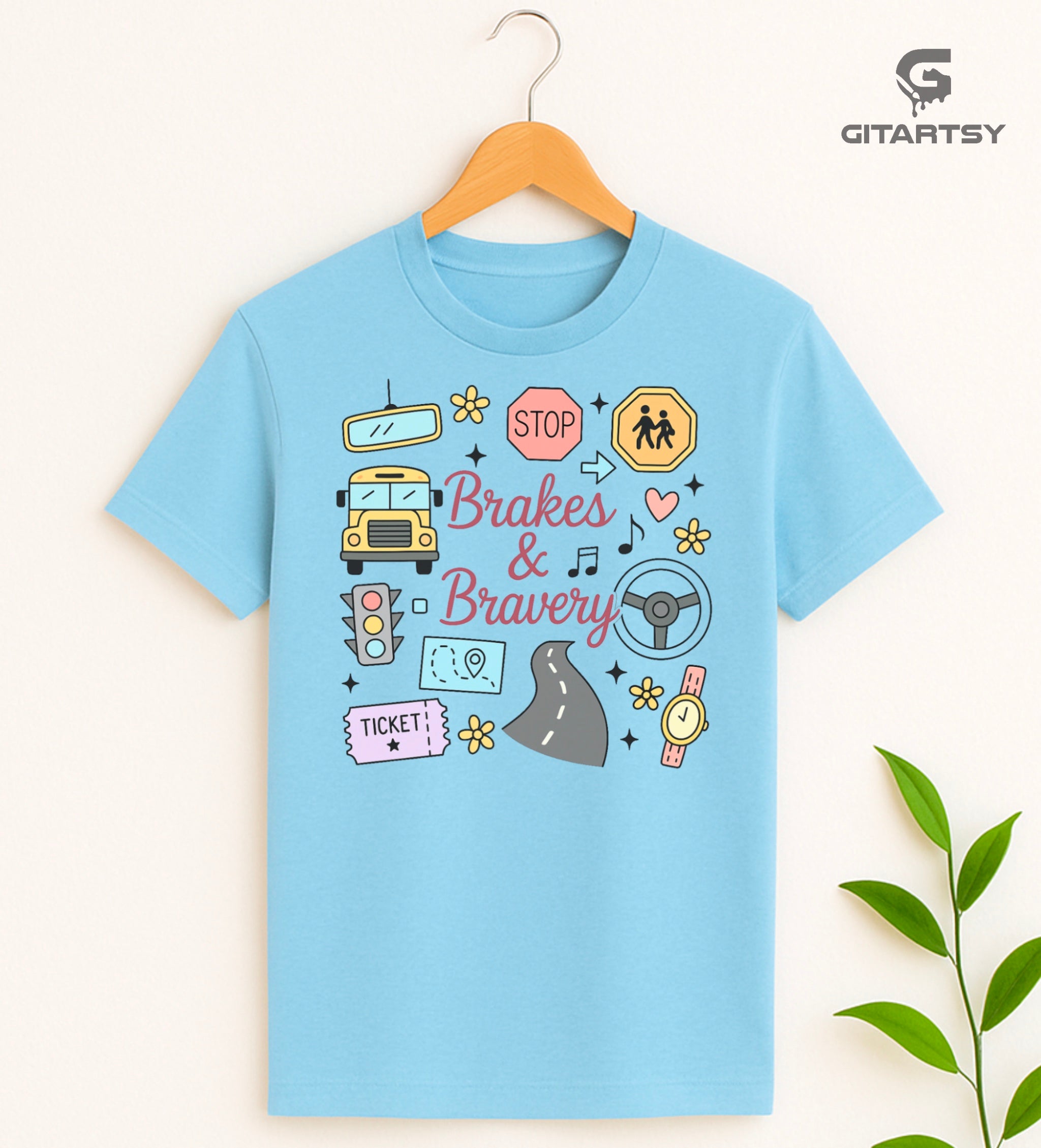 Pastel T-shirt with “Brakes & Bravery” design featuring illustrated school bus, road signs, steering wheel, and driving elements – ideal gift for bus drivers and transport staff