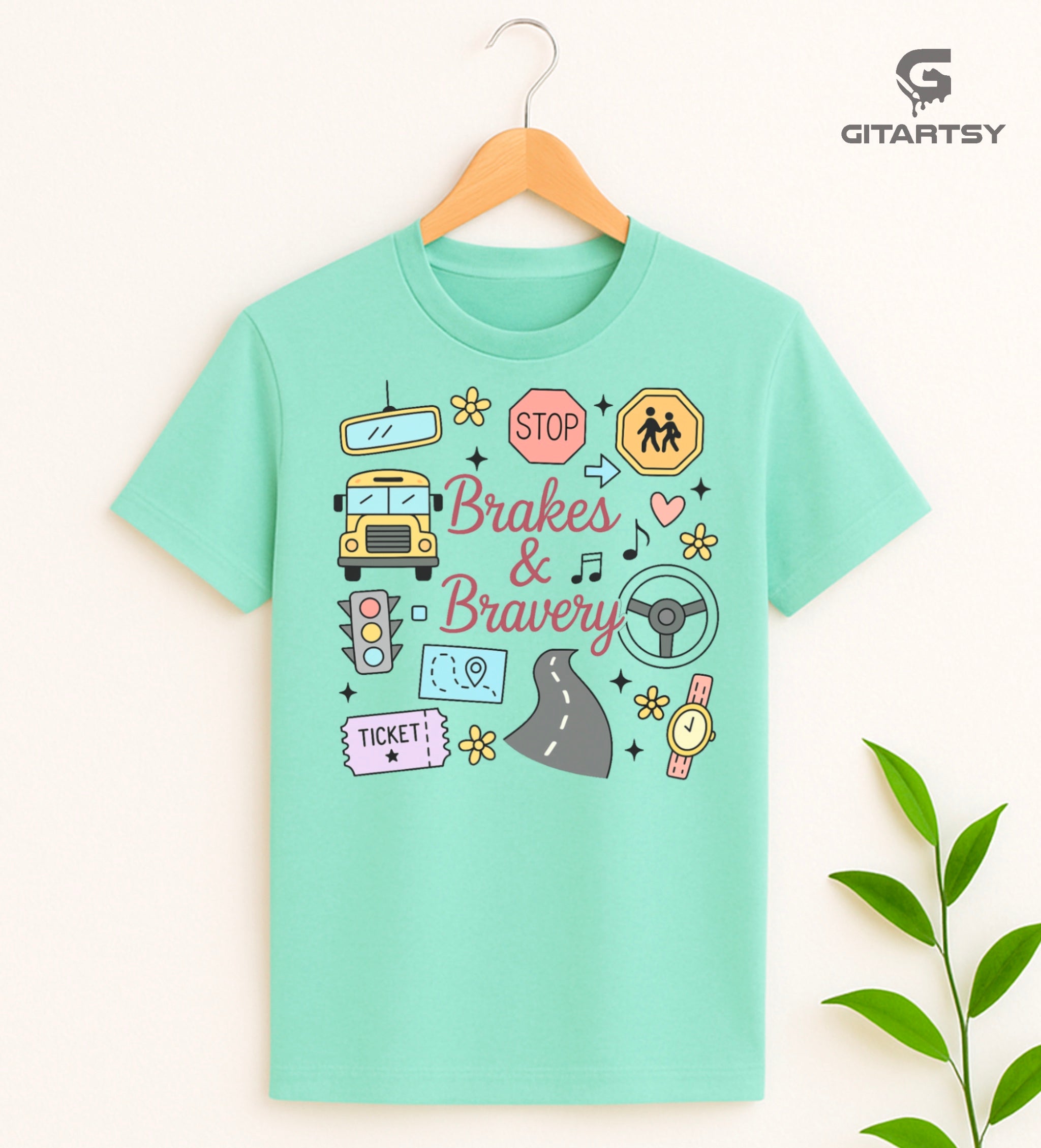 Pastel T-shirt with “Brakes & Bravery” design featuring illustrated school bus, road signs, steering wheel, and driving elements – ideal gift for bus drivers and transport staff