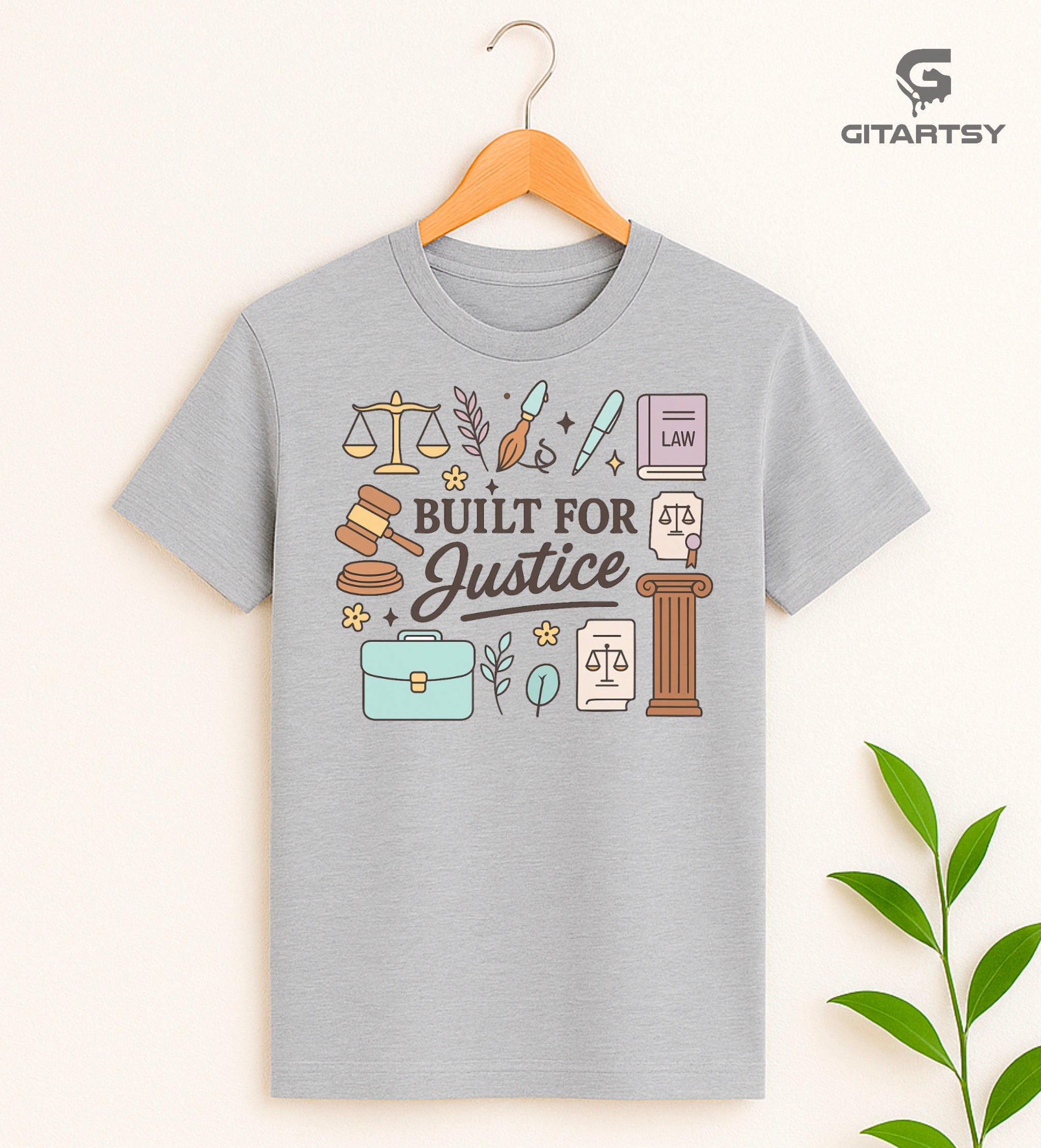 T-shirt featuring the quote "Built for Justice" surrounded by pastel legal icons like scales, gavel, law books, pens, briefcase, and courthouse pillar – ideal for lawyers and law students.
