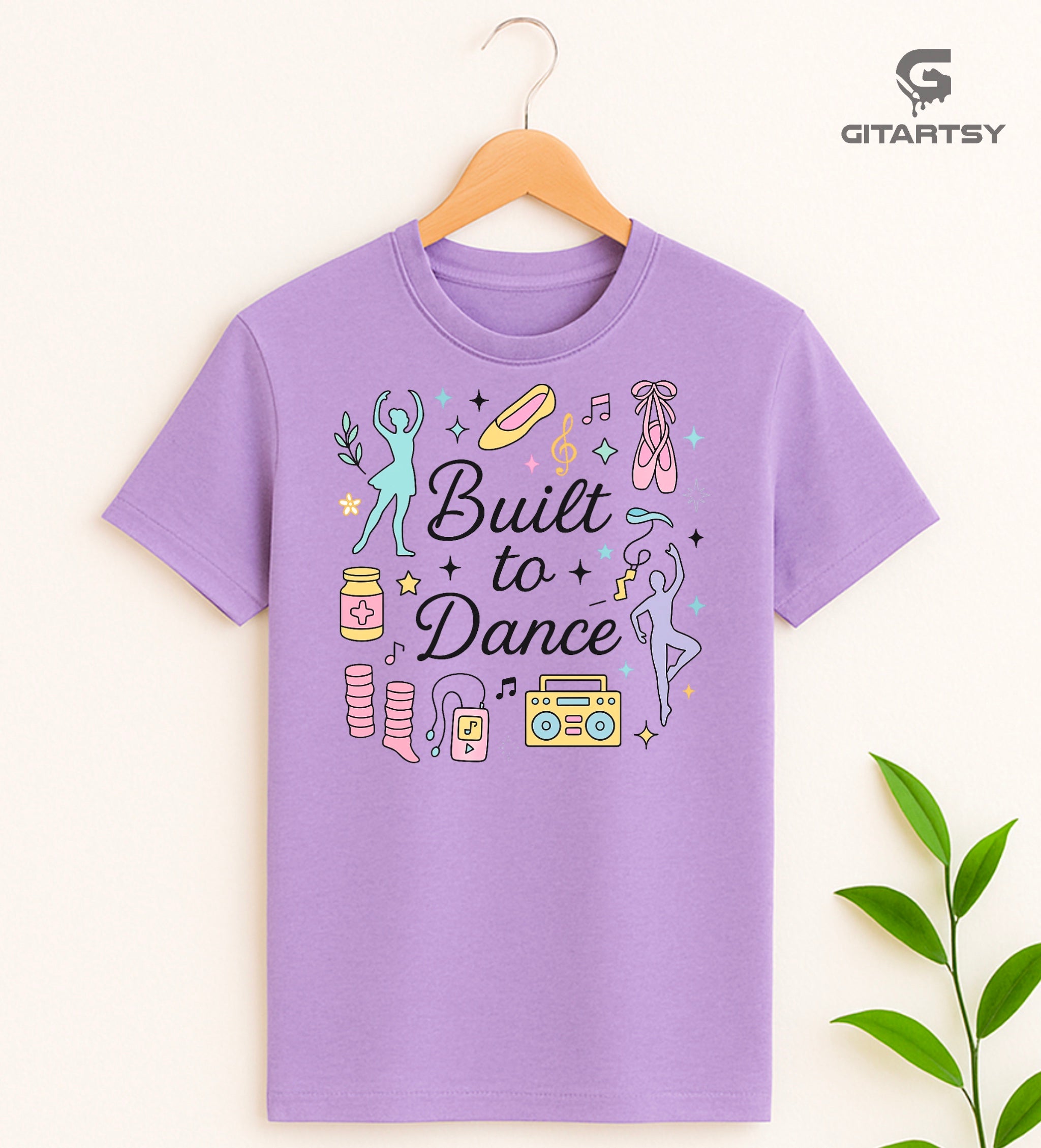 Pastel t-shirt with the phrase "Built to Dance" surrounded by dancer silhouettes, ballet shoes, leg warmers, and music symbols – ideal for dance lovers, choreographers, and teachers.