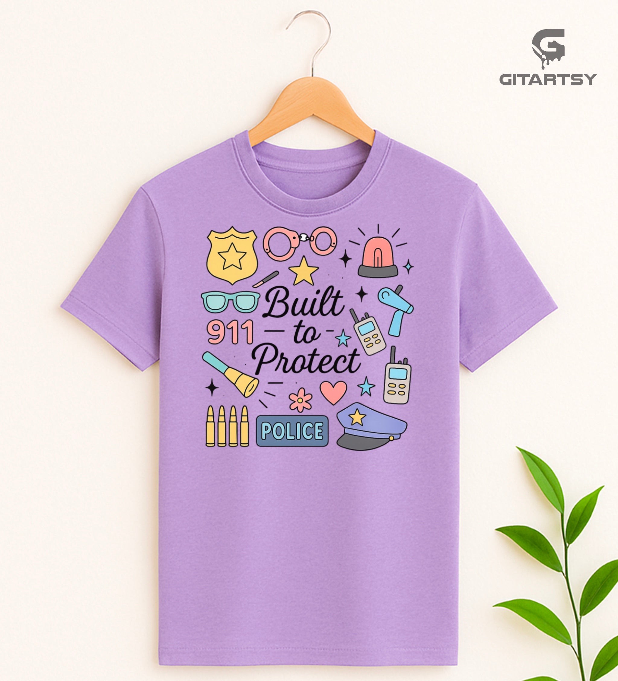 Pastel graphic T-shirt for policewomen with icons like badges, handcuffs, sirens, and 911 – “Built to Protect” slogan in stylish typography.