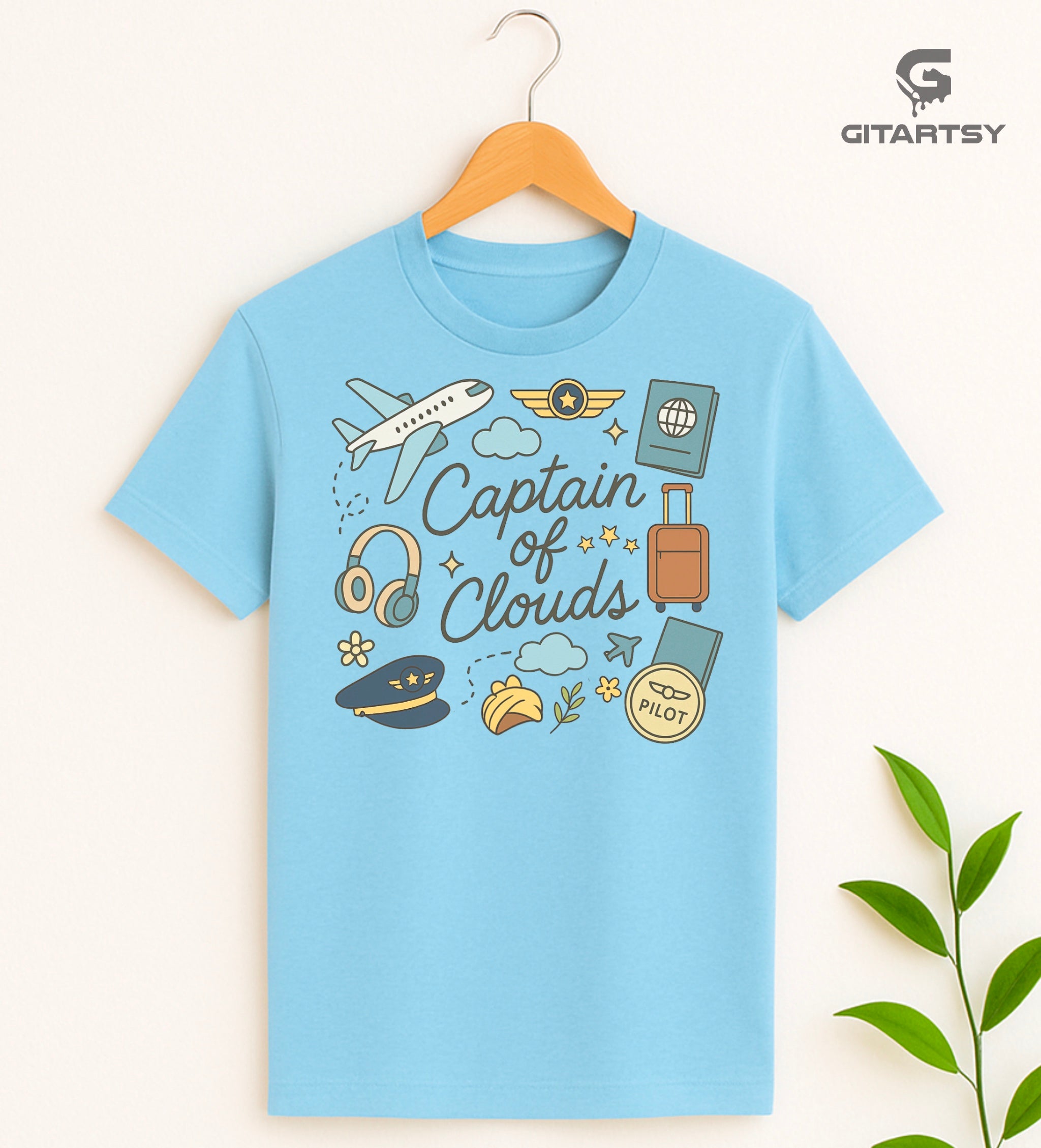 Pastel pilot-themed t-shirt with plane, cloud, headset, and travel icons. "Captain of Clouds" design for aviation lovers and airline crew.