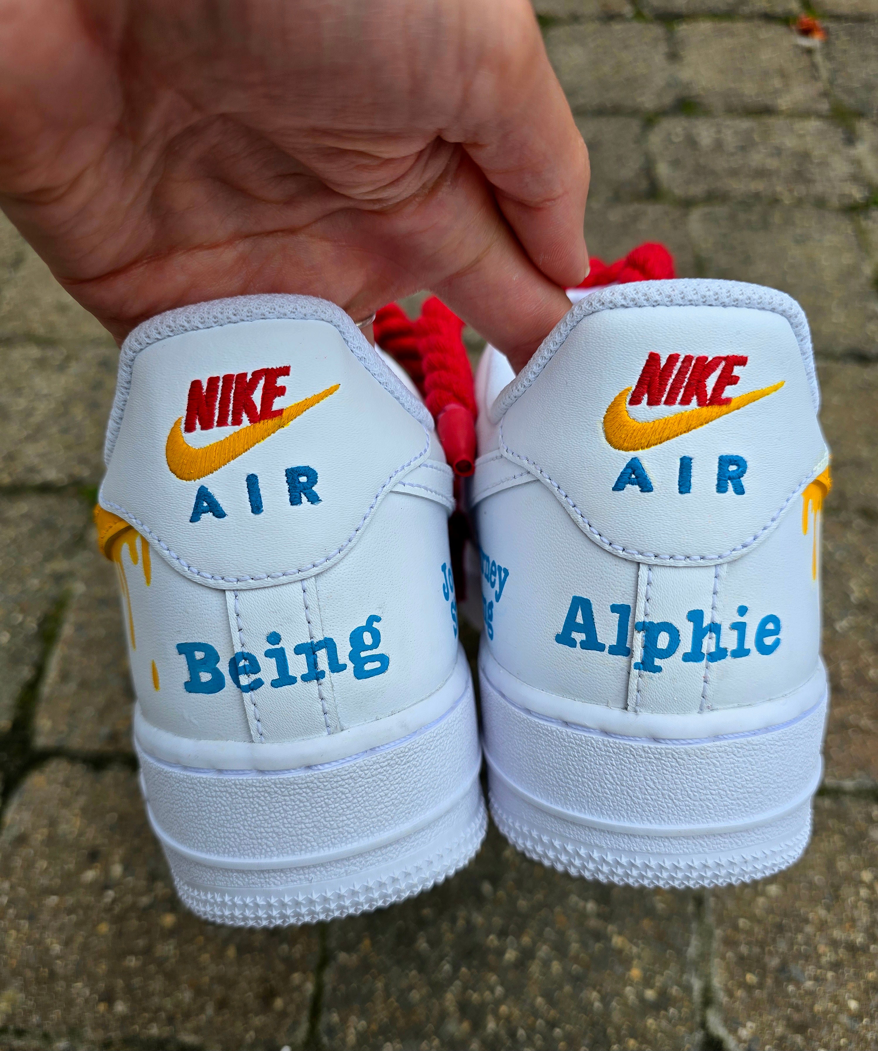 Custom hand-painted Nike Air Force 1 sneakers featuring unique cartoon artwork inspired by the book Who Stole Your Mind? by Being Alphie. The shoes showcase vibrant illustrations, bright yellow swoosh drips, thick red rope laces, and hand-lettered text on premium leather for book lovers, art collectors, and streetwear fans.

