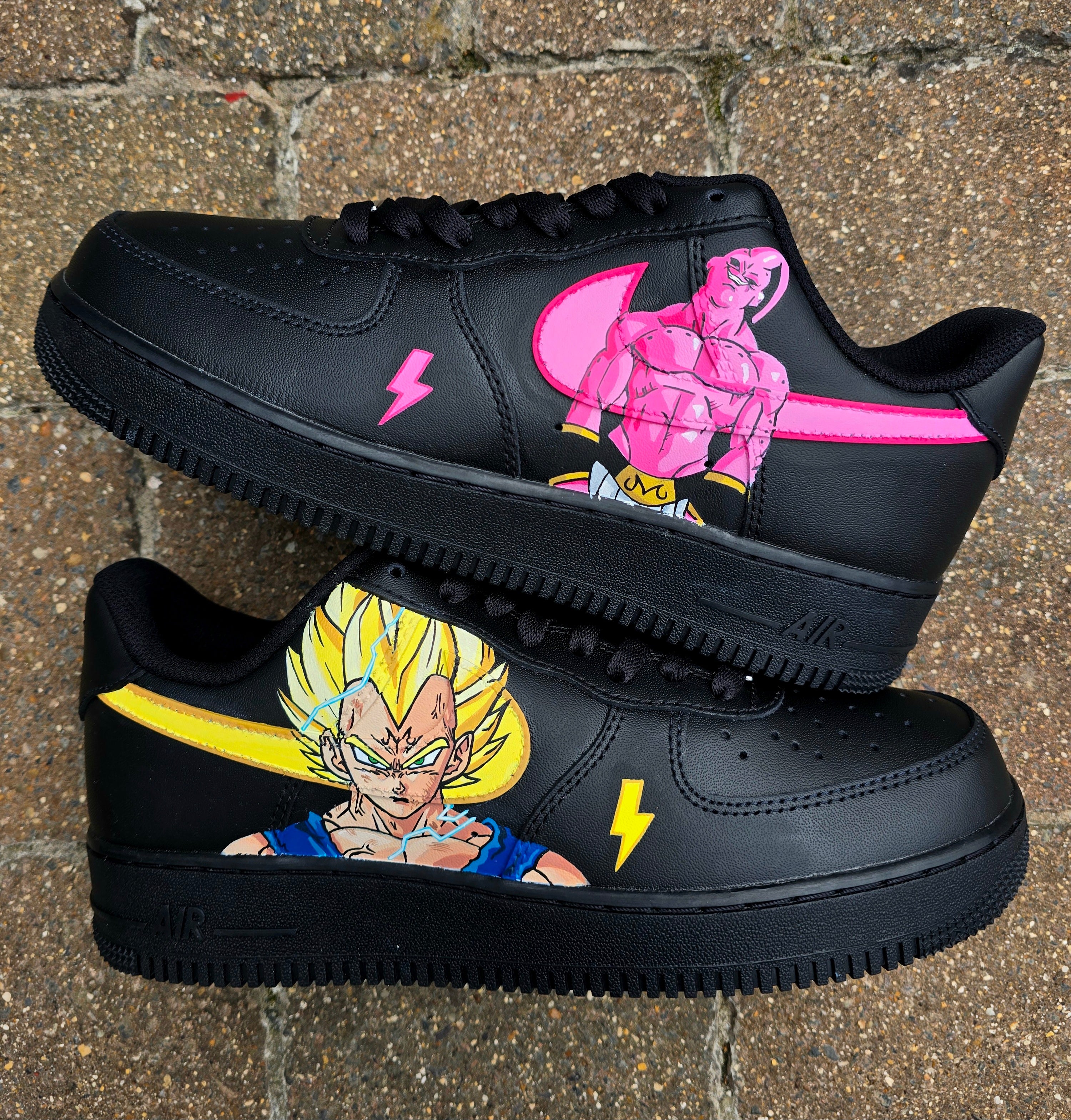 Custom Dragon Ball Z Nike Air Force 1 sneakers featuring hand-painted anime artwork of Majin Buu and Super Saiyan Goku. Black leather base with pink and yellow accents, lightning bolt details, and high-quality, waterproof custom paint job.

