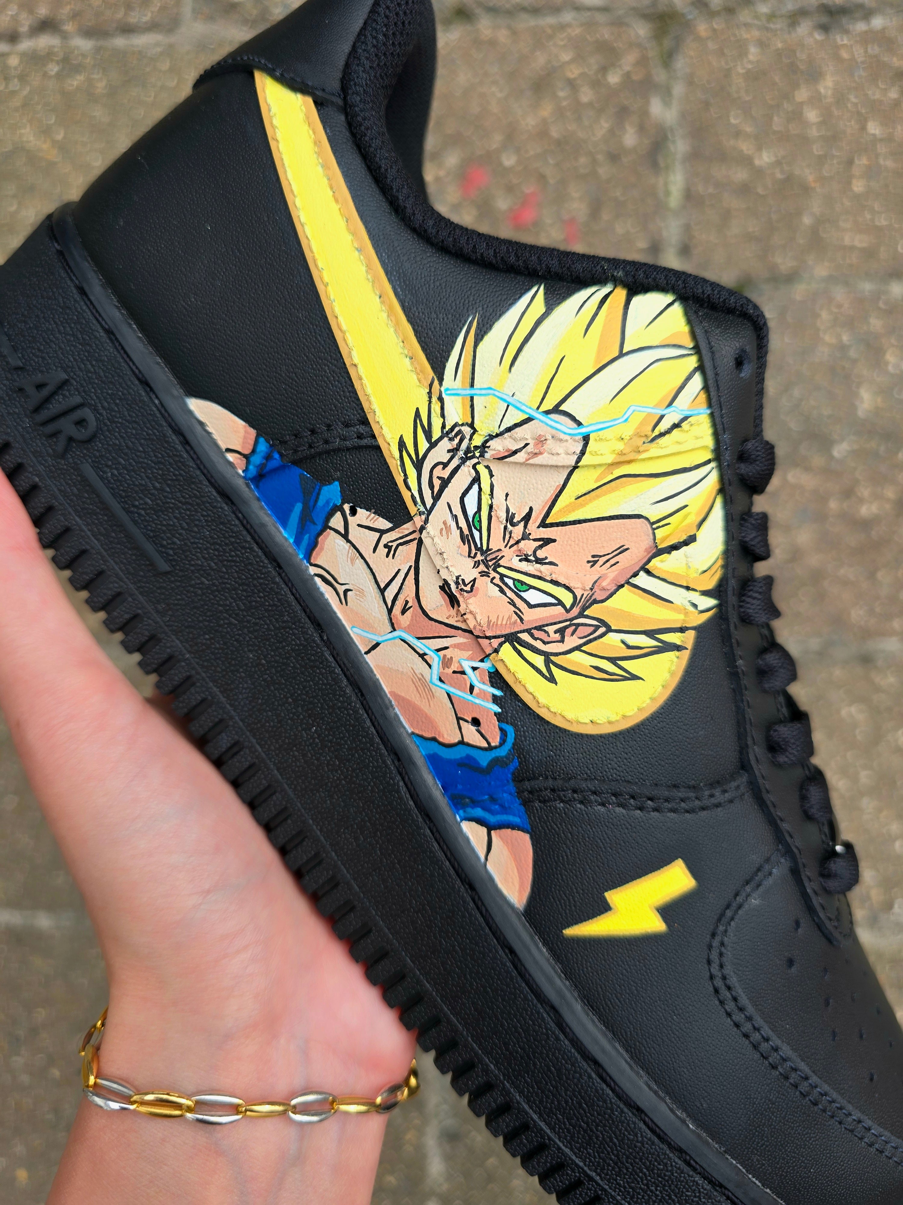 Custom Dragon Ball Z Nike Air Force 1 sneakers featuring hand-painted anime artwork of Majin Buu and Super Saiyan Goku. Black leather base with pink and yellow accents, lightning bolt details, and high-quality, waterproof custom paint job.

