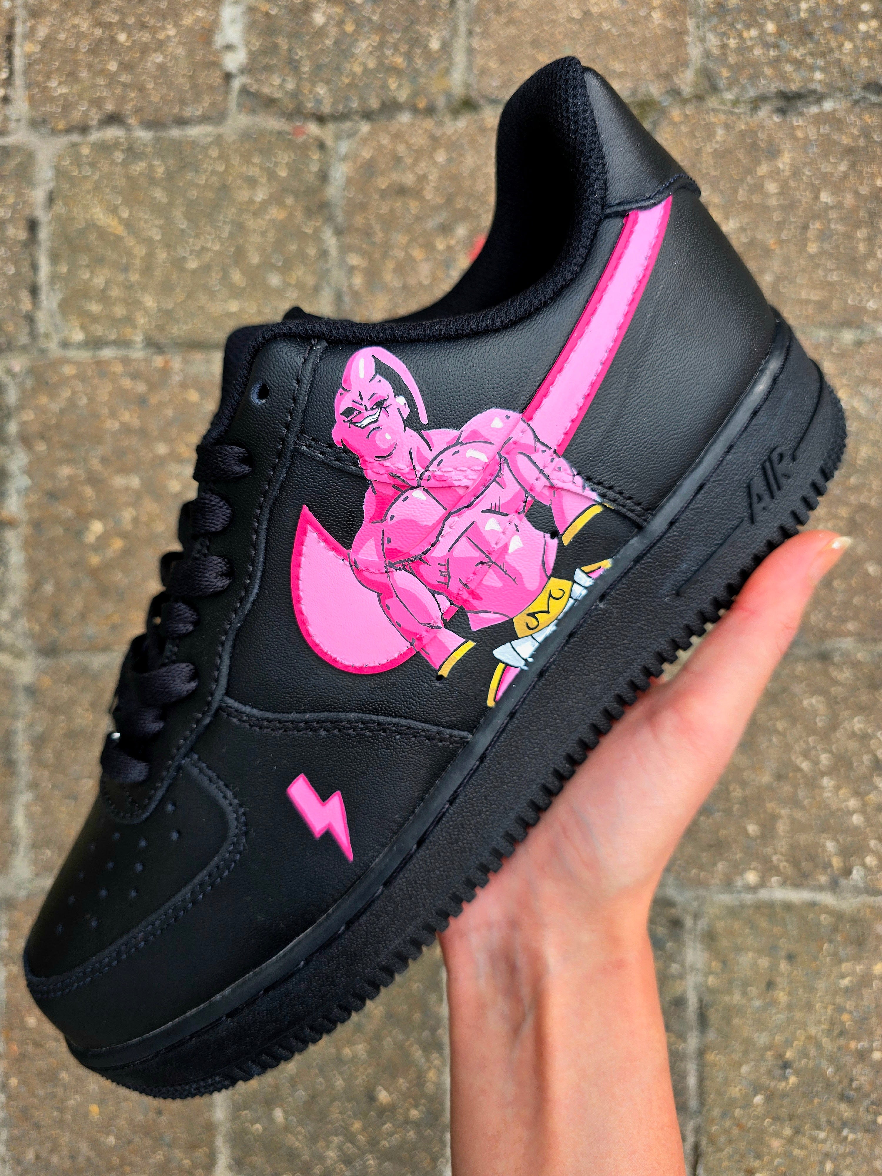 Custom Dragon Ball Z Nike Air Force 1 sneakers featuring hand-painted anime artwork of Majin Buu and Super Saiyan Goku. Black leather base with pink and yellow accents, lightning bolt details, and high-quality, waterproof custom paint job.

