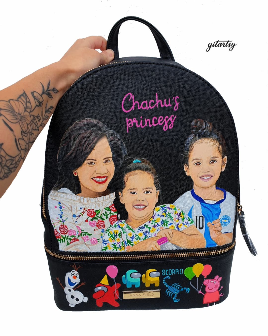 Custom family portrait hand-painted backpack showing a smiling mother and two daughters on the front panel, with colorful characters and zodiac motifs at the bottom; crafted with premium leather paints, showcasing personalized details like names, favorite cartoons, and astrological signs.

