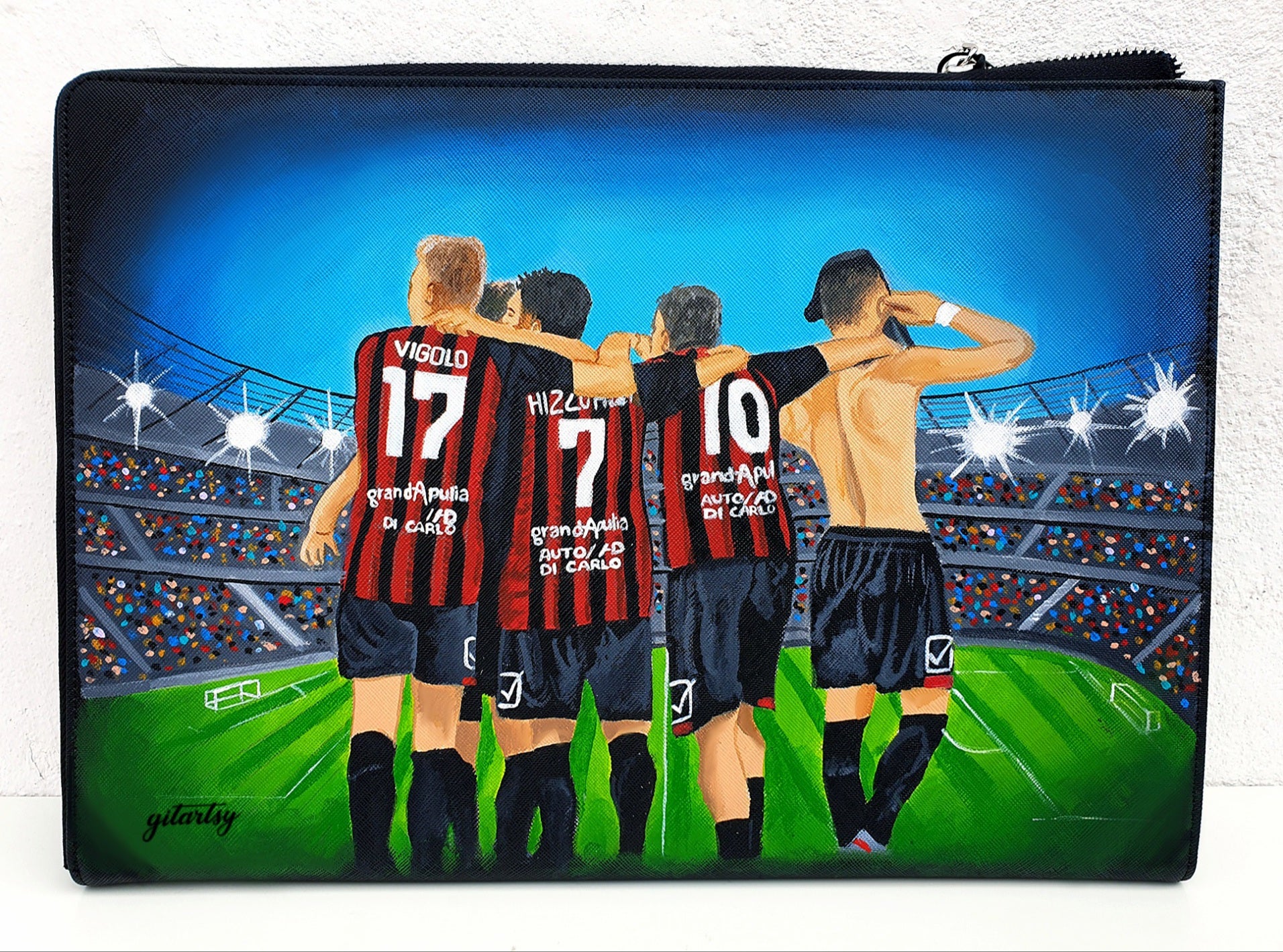 Custom hand-painted footballer artwork wallet depicting four players in red and black striped jerseys with names and numbers, standing arm-in-arm on a stadium field under bright lights, perfect for football fans and players, crafted on a black canvas zippered pouch with vivid colors and intricate details.

