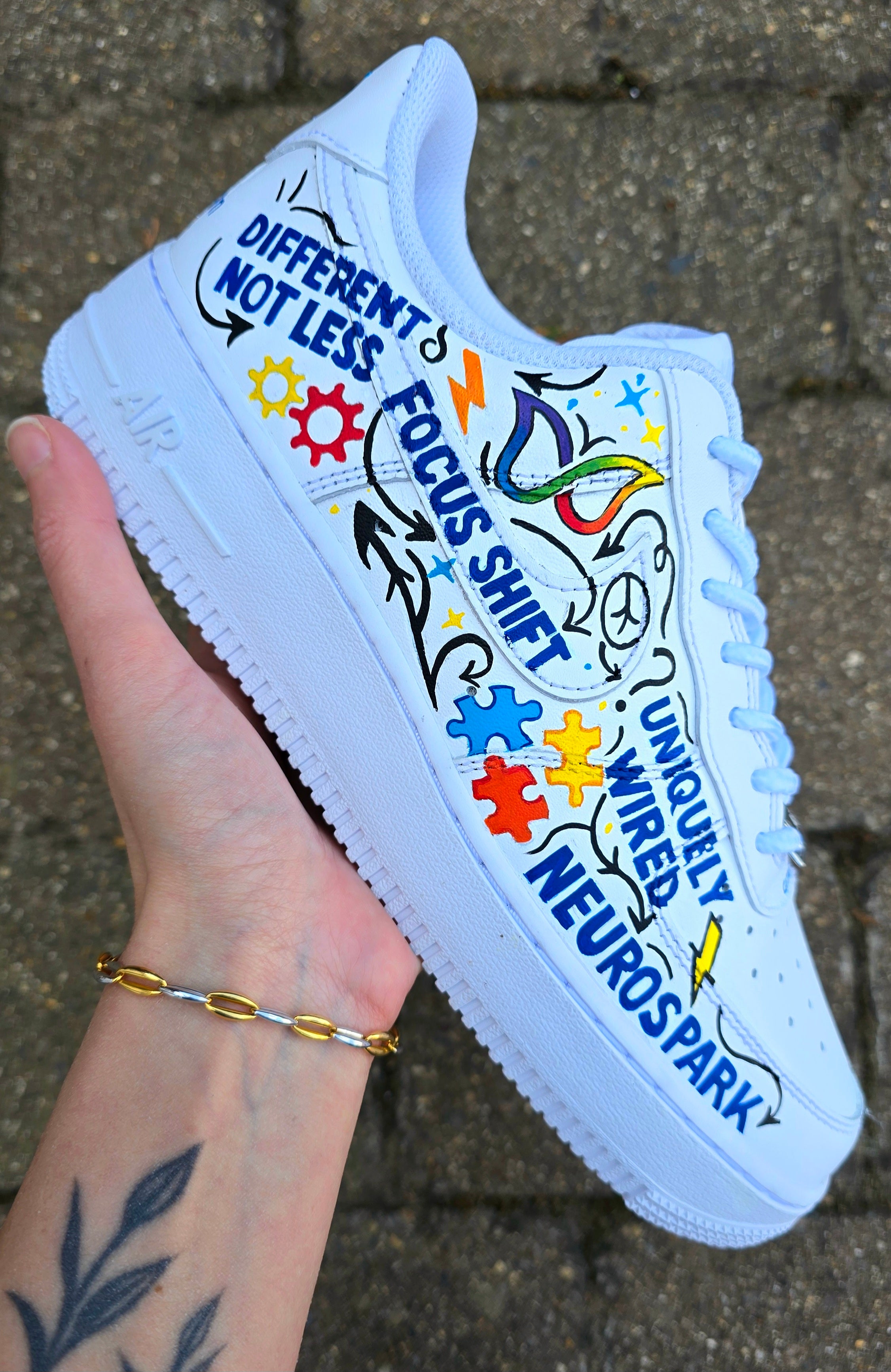 Custom hand-painted Nike Air Force 1 sneakers featuring a vibrant ADHD and Autism awareness design. Includes colourful puzzle pieces, infinity symbols, inspirational typography, and Chelsea FC Foundation branding. Crafted using waterproof and UV-protected leather paints for long-lasting wear. Each pair is unique, representing creativity, inclusivity, and neurodiversity. Perfect for collectors, awareness events, and personal expression.


