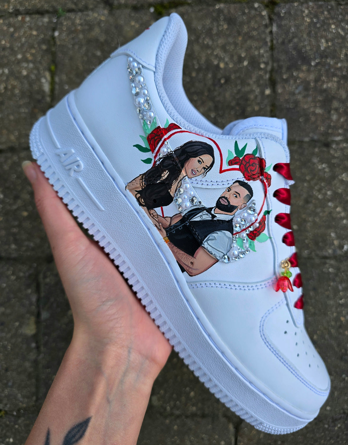 A white custom sneaker with a graphic illustration of a couple, red roses, heart border proposal photo and rhinestone embellishments, The brand name 'GITARTSY' is visible in the top right. Colour scheme is red maroon and white black 