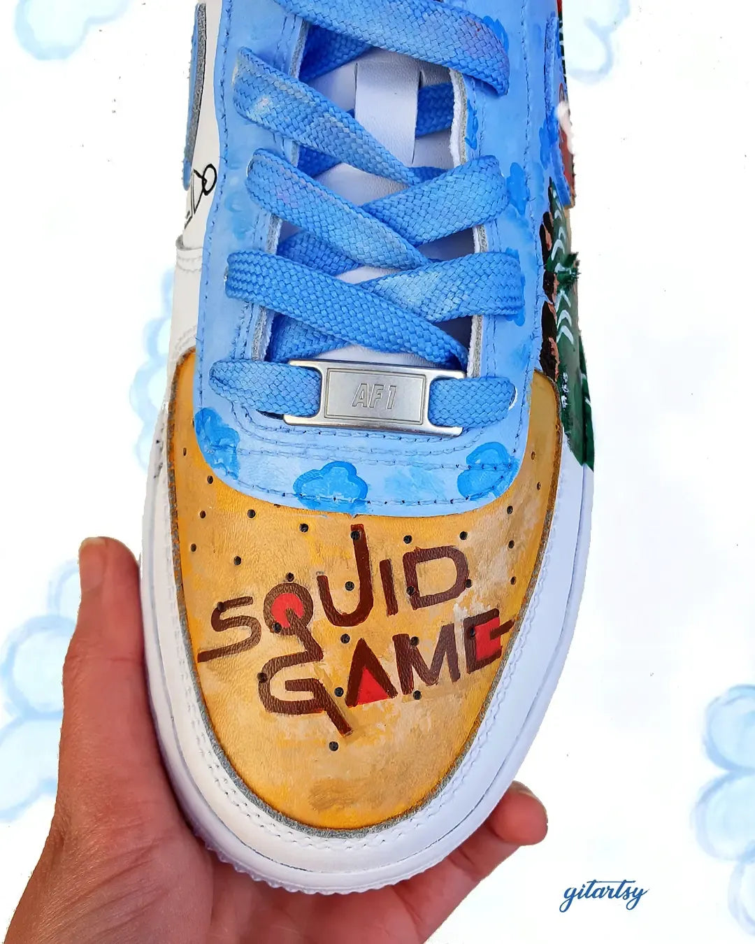 Netflix series Squid Game doll, guards and icons painted on Nike AF1 sneakers with detailed blue sky background - zoomed in view