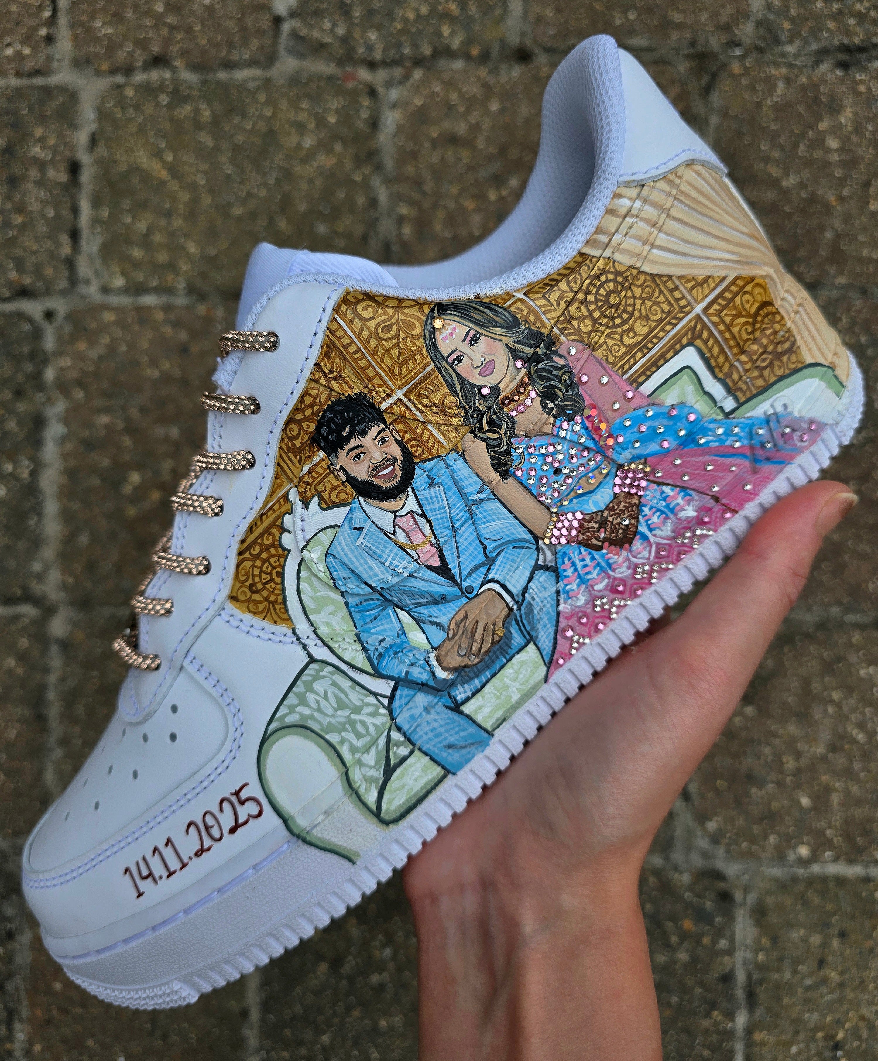 White sneaker with a hand-painted design of a couple and personalized text, held against a textured brown background.