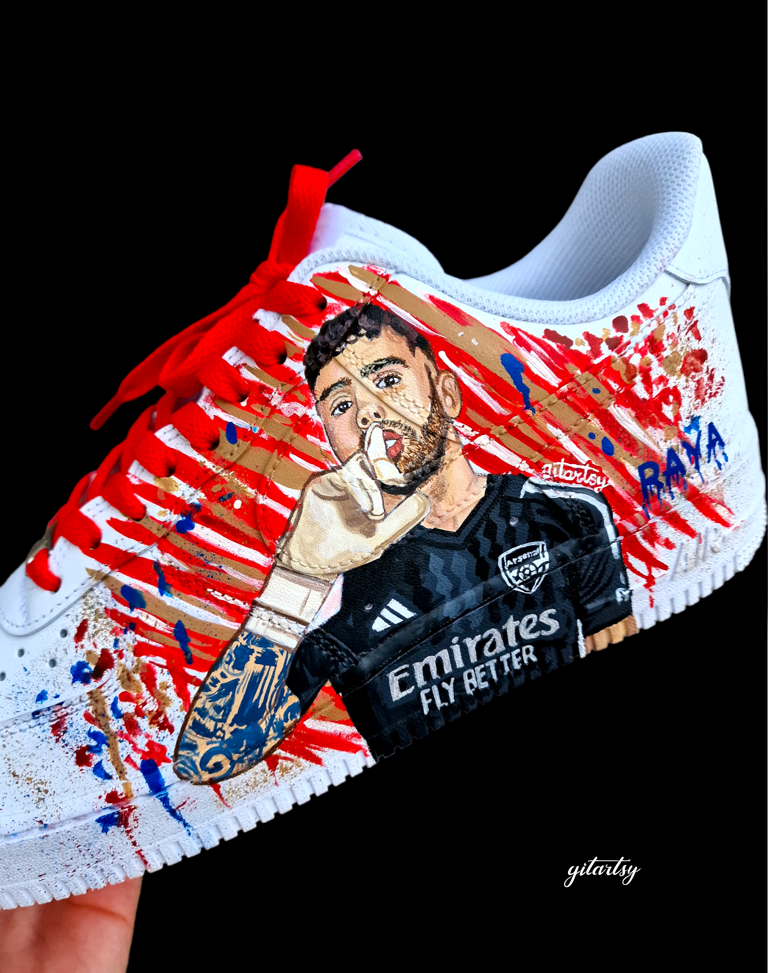 Hand-painted custom Nike Air Force 1 sneakers featuring David Raya in Arsenal goalkeeper kit, Arsenal crest, Spanish flag and colors, vibrant football-inspired splatter artwork, crafted by Gitartsy.

