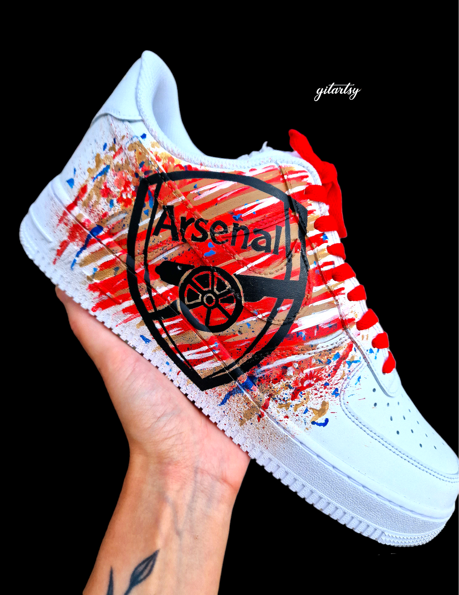 Hand-painted custom Nike Air Force 1 sneakers featuring David Raya in Arsenal goalkeeper kit, Arsenal crest, Spanish flag and colors, vibrant football-inspired splatter artwork, crafted by Gitartsy.

