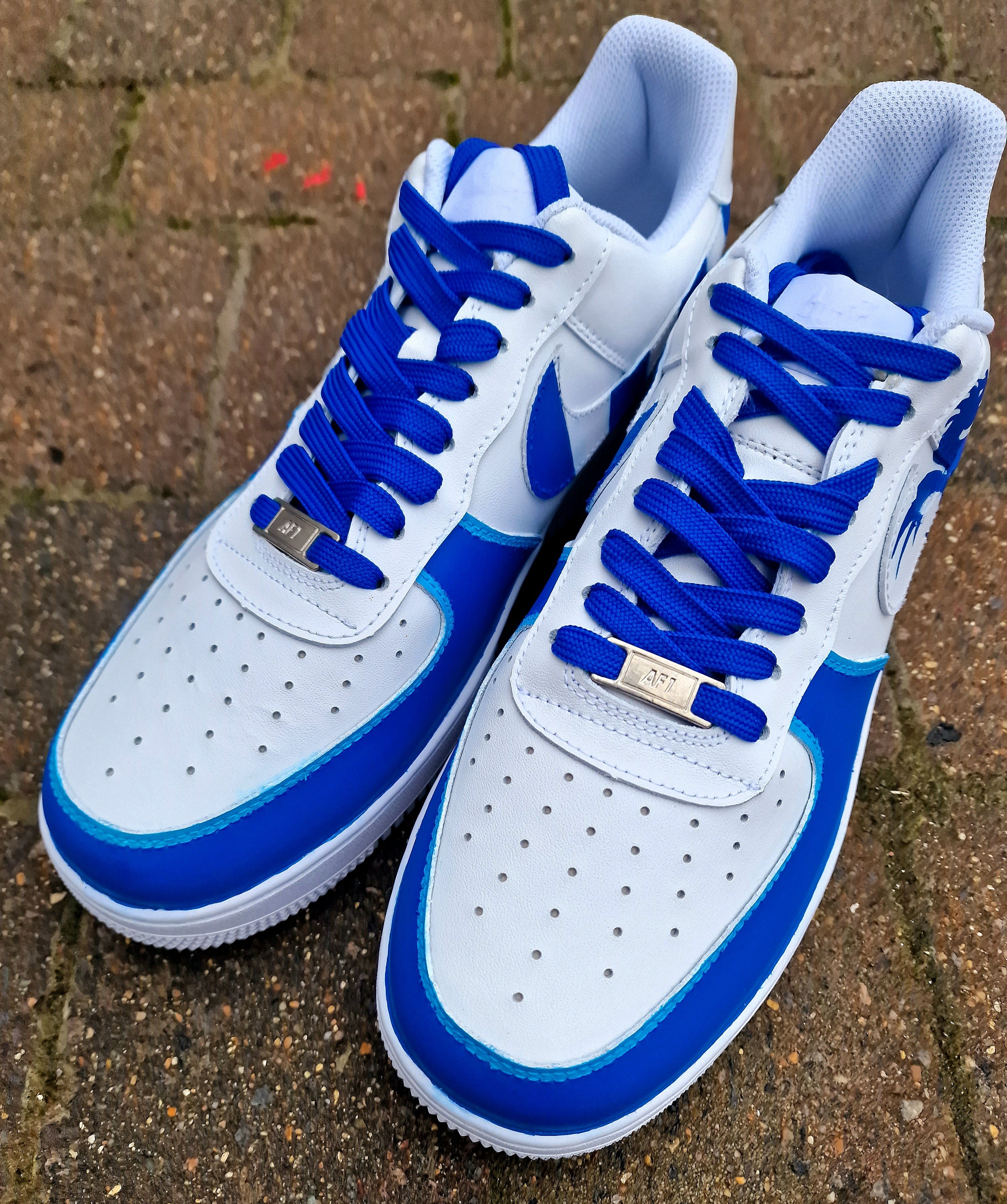 Custom FC Porto Nike Air Force 1 sneakers designed for football fans, featuring hand-painted artwork with the official club crest, blue and white color scheme, dragon mascot, and player number detailing. These one-of-a-kind shoes are crafted using authentic Nike AF1s and painted with weather-resistant leather paints. Perfect for sports lovers and collectors, combining comfort with team spirit.

