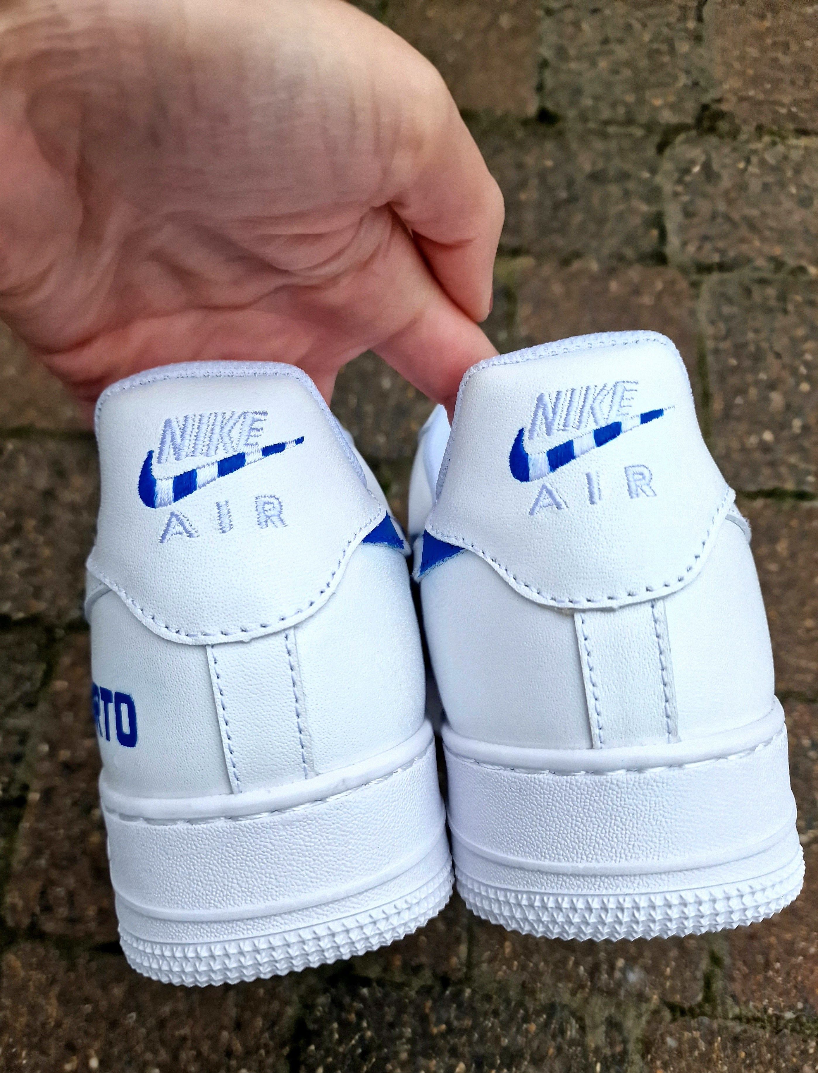 Custom FC Porto Nike Air Force 1 sneakers designed for football fans, featuring hand-painted artwork with the official club crest, blue and white color scheme, dragon mascot, and player number detailing. These one-of-a-kind shoes are crafted using authentic Nike AF1s and painted with weather-resistant leather paints. Perfect for sports lovers and collectors, combining comfort with team spirit.

