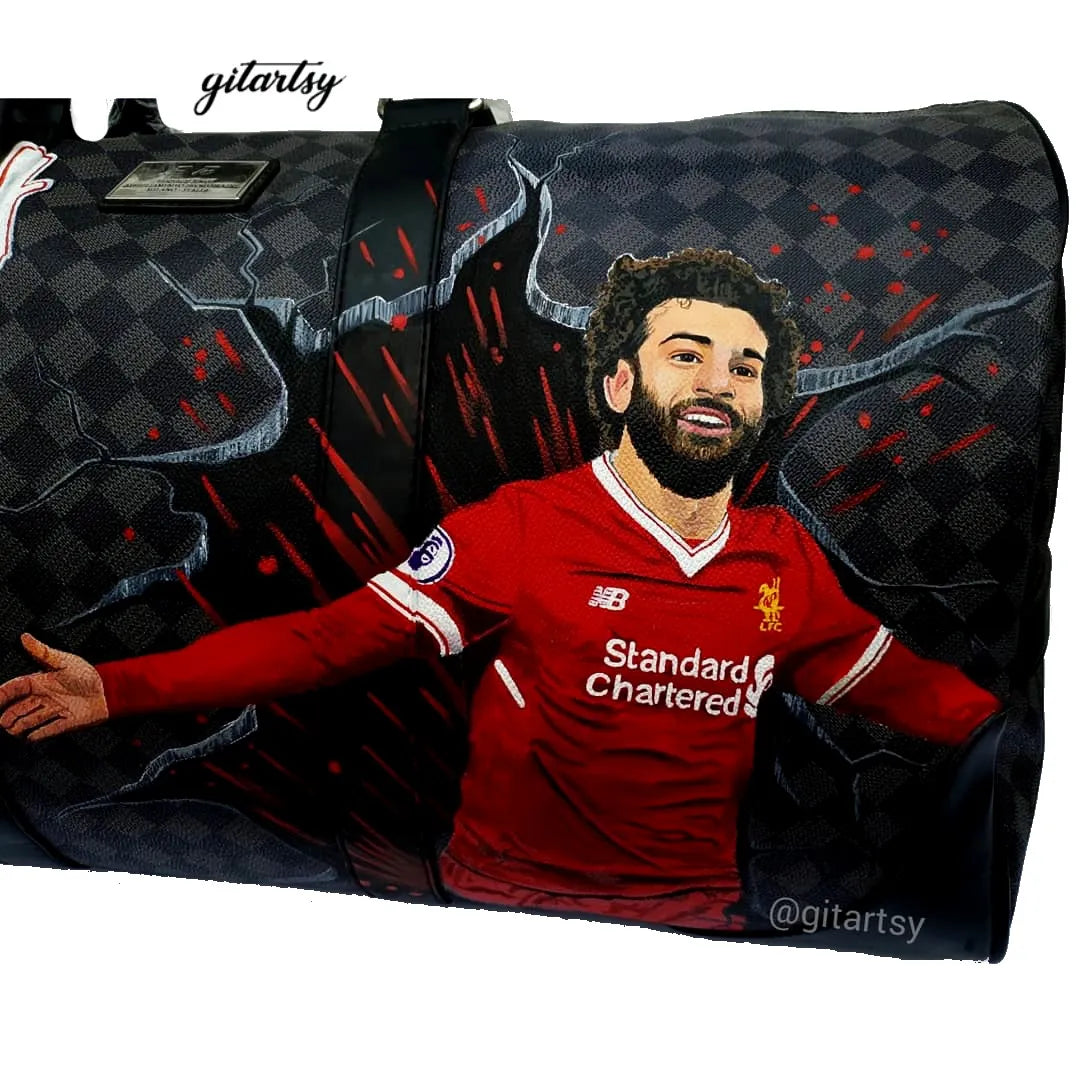 Footballer Mohamed Salah from Liverpool LFC's portrait hand painted on a large duffle bag with his name and a football