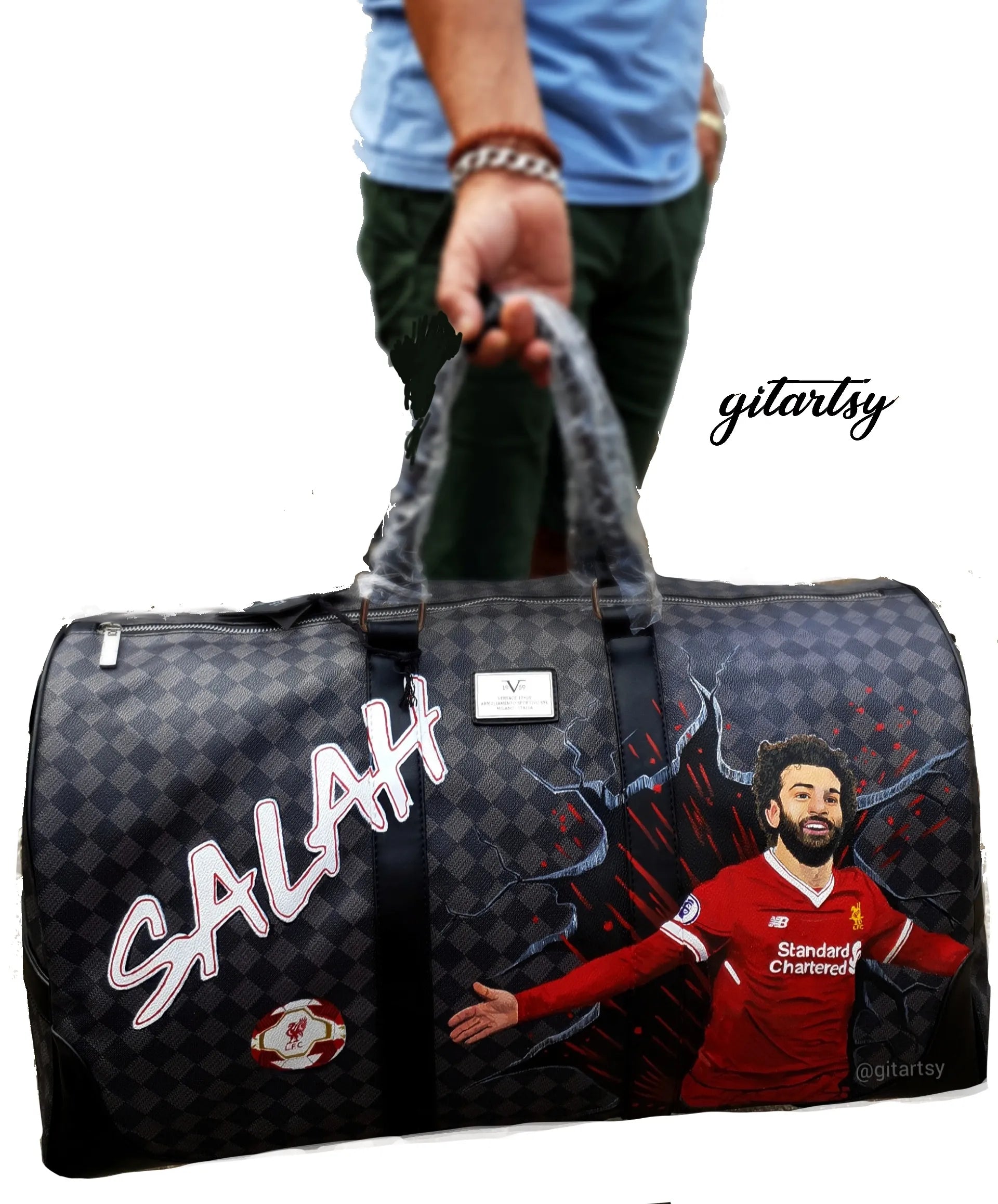 Footballer Mohamed Salah from Liverpool LFC's portrait hand painted on a large duffle bag with his name and a football
