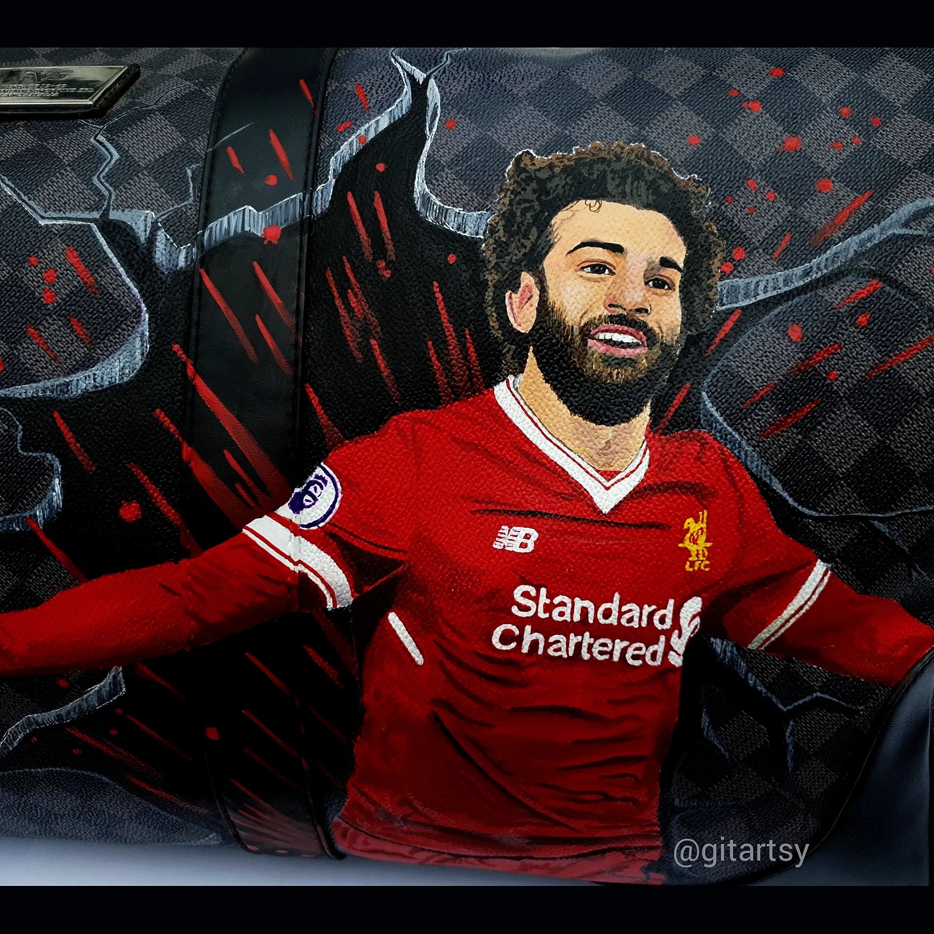 Footballer Mohamed Salah from Liverpool LFC's portrait hand painted on a large duffle bag with his name and a football