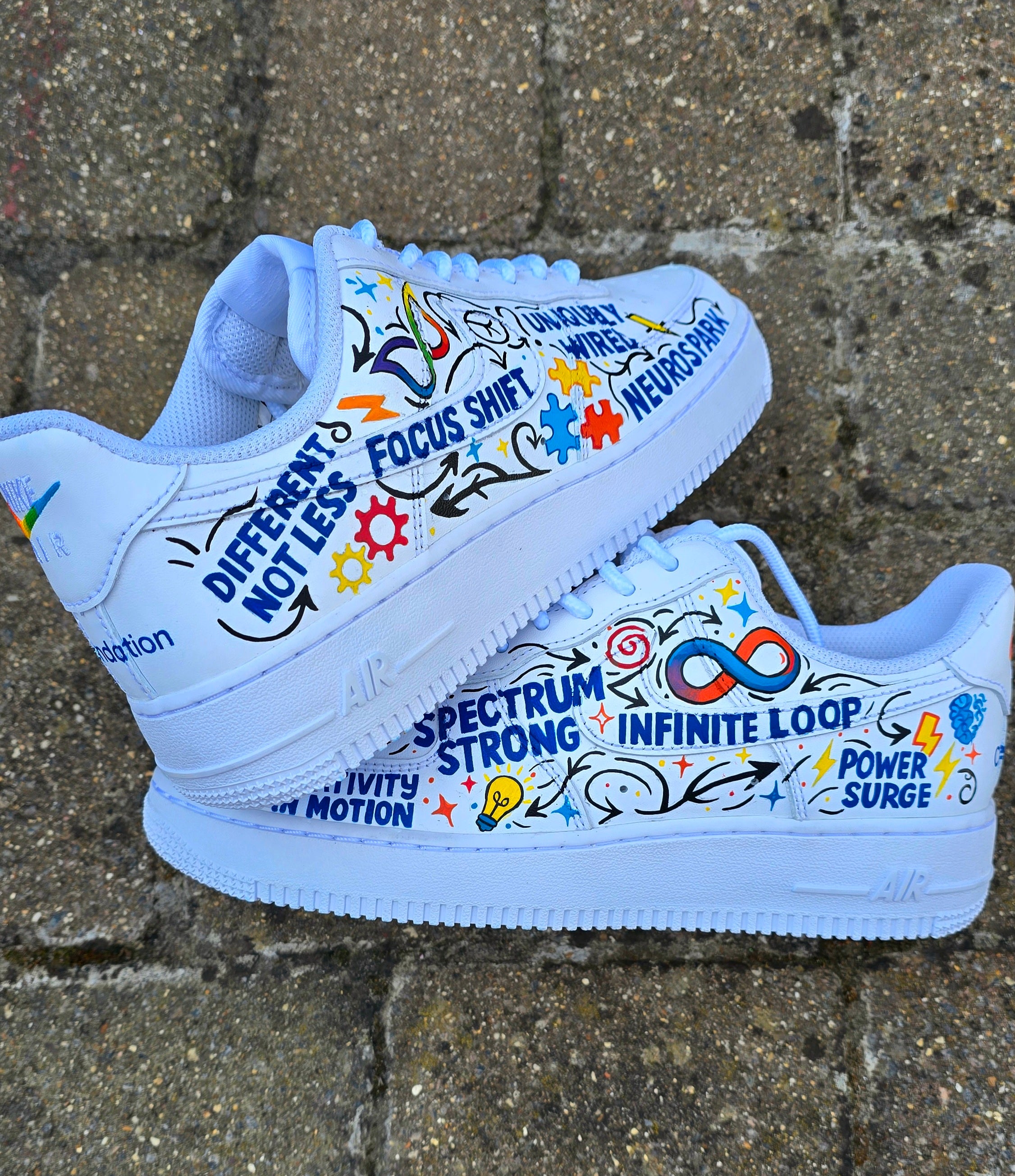 Custom hand-painted Nike Air Force 1 sneakers featuring a vibrant ADHD and Autism awareness design. Includes colourful puzzle pieces, infinity symbols, inspirational typography, and Chelsea FC Foundation branding. Crafted using waterproof and UV-protected leather paints for long-lasting wear. Each pair is unique, representing creativity, inclusivity, and neurodiversity. Perfect for collectors, awareness events, and personal expression.

