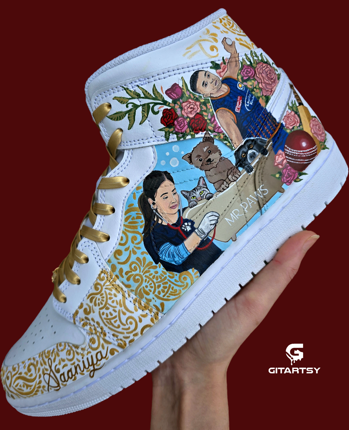 A pair of nike jordan 1 white high-top sneakers with custom illustrations of a couple Arjun Tendulkar and Saaniya Chandhok with gold paisley patterns henna, pets, florals with maroon and blue colour scheme displayed against a dark red background with a GITARTSY logo in the corner.