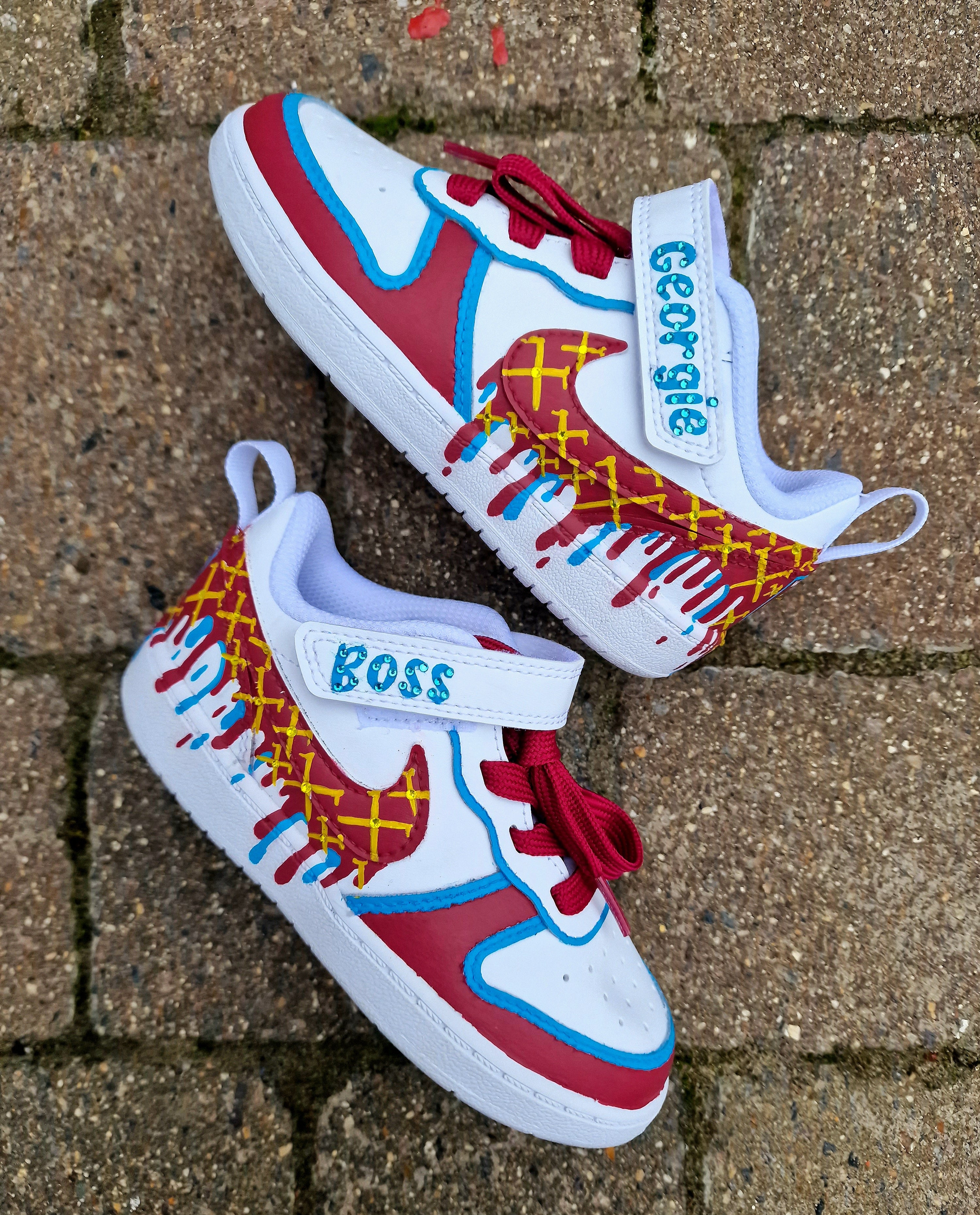 Custom hand-painted baby sneakers inspired by West Ham United, featuring claret and blue color detailing, dripping paint effect, crossed hammers, and personalised names or messages on the straps. Perfect for infant football fans and thoughtful baby gifts.

