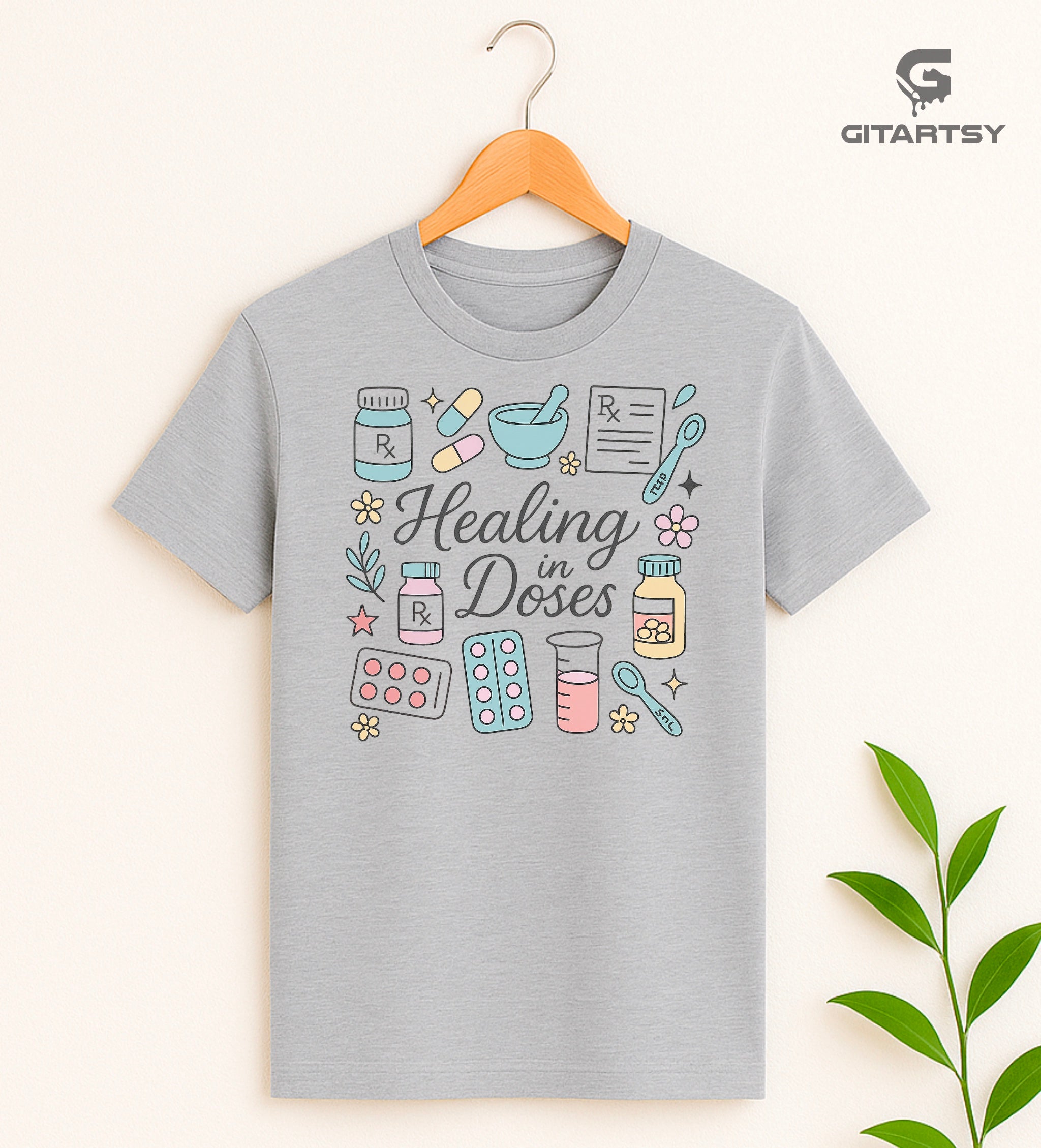 T-shirt with the phrase "Healing in Doses" featuring pastel illustrations of medical elements such as pills, prescription bottles, RX sheets, thermometers, and beakers – ideal for healthcare professionals and pharmacy lovers.