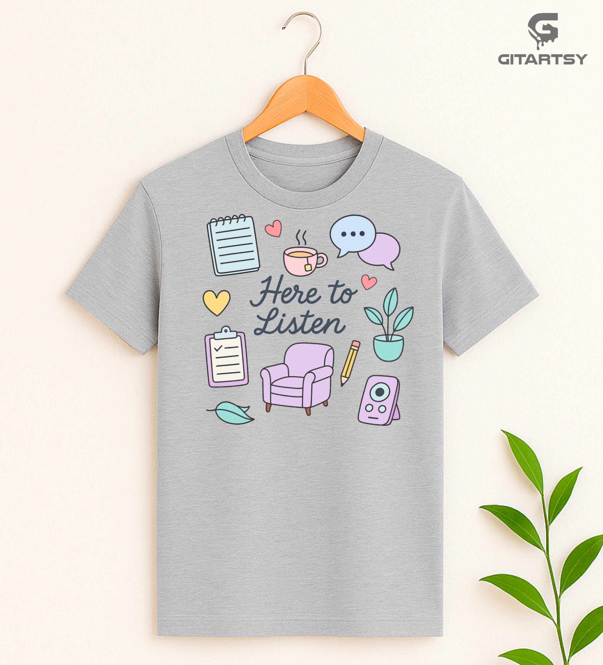 Pastel T-shirt with “Here to Listen” quote and illustrated therapy icons like a chair, speech bubbles, notebook, plant, and heart - ideal for therapists and mental health professionals 