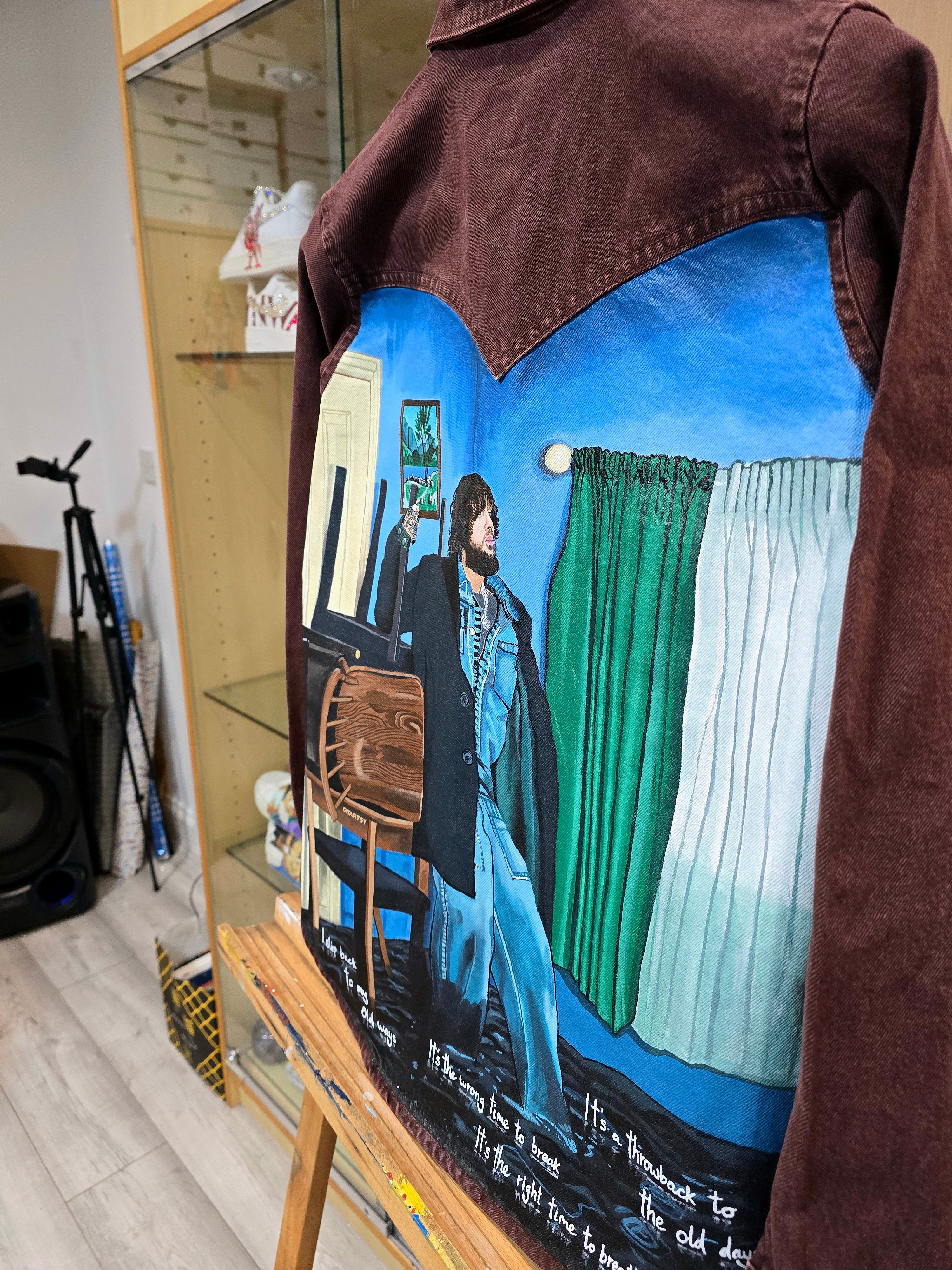 James Arthur Singer Hand Painted Denim Jacket featuring a detailed back artwork of James Arthur in a vibrant indoor scene, painted on a burgundy denim jacket with “Pisces” embroidered on the front, created by Gitartsy using high-quality fabric paints for long-lasting wear.
