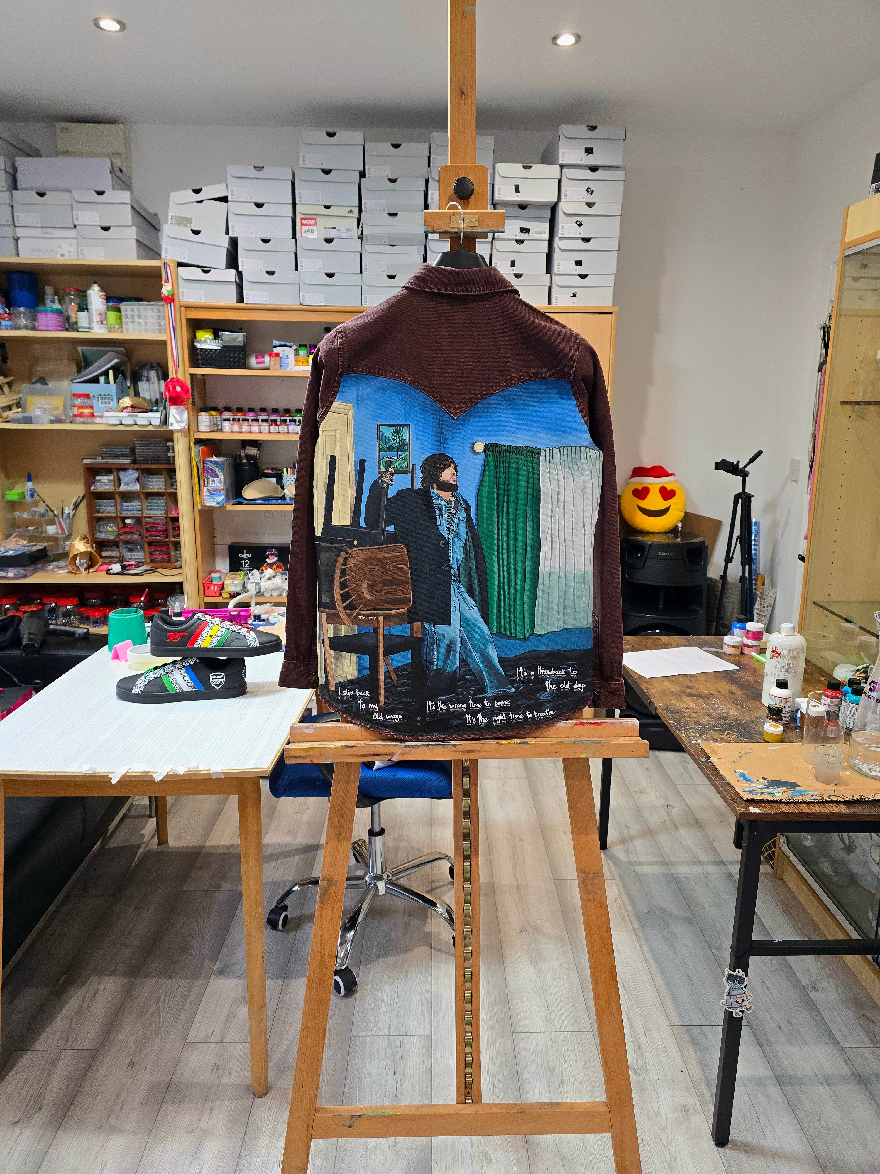 James Arthur Singer Hand Painted Denim Jacket featuring a detailed back artwork of James Arthur in a vibrant indoor scene, painted on a burgundy denim jacket with “Pisces” embroidered on the front, created by Gitartsy using high-quality fabric paints for long-lasting wear.

