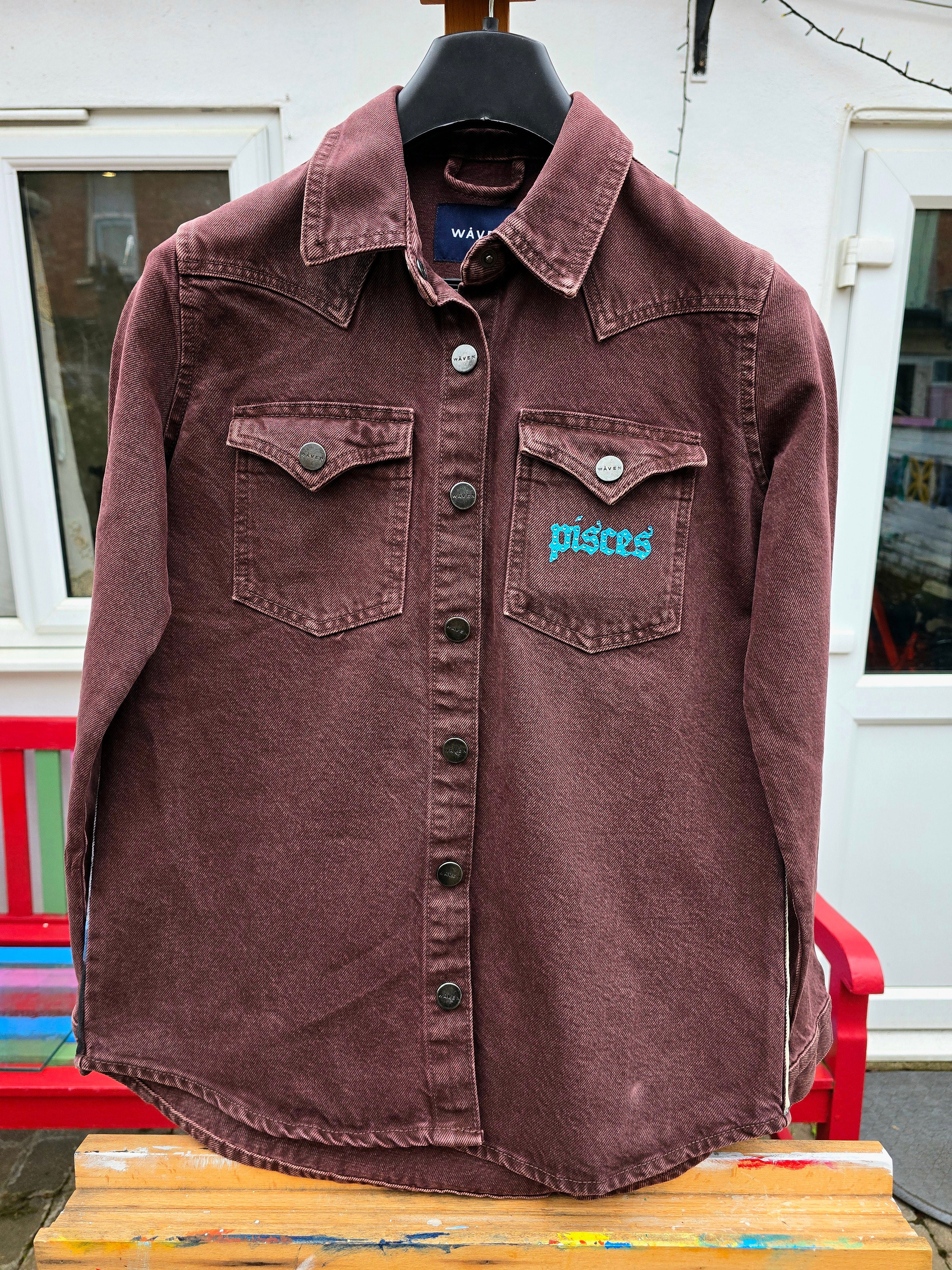 James Arthur Singer Hand Painted Denim Jacket featuring a detailed back artwork of James Arthur in a vibrant indoor scene, painted on a burgundy denim jacket with “Pisces” embroidered on the front, created by Gitartsy using high-quality fabric paints for long-lasting wear.

