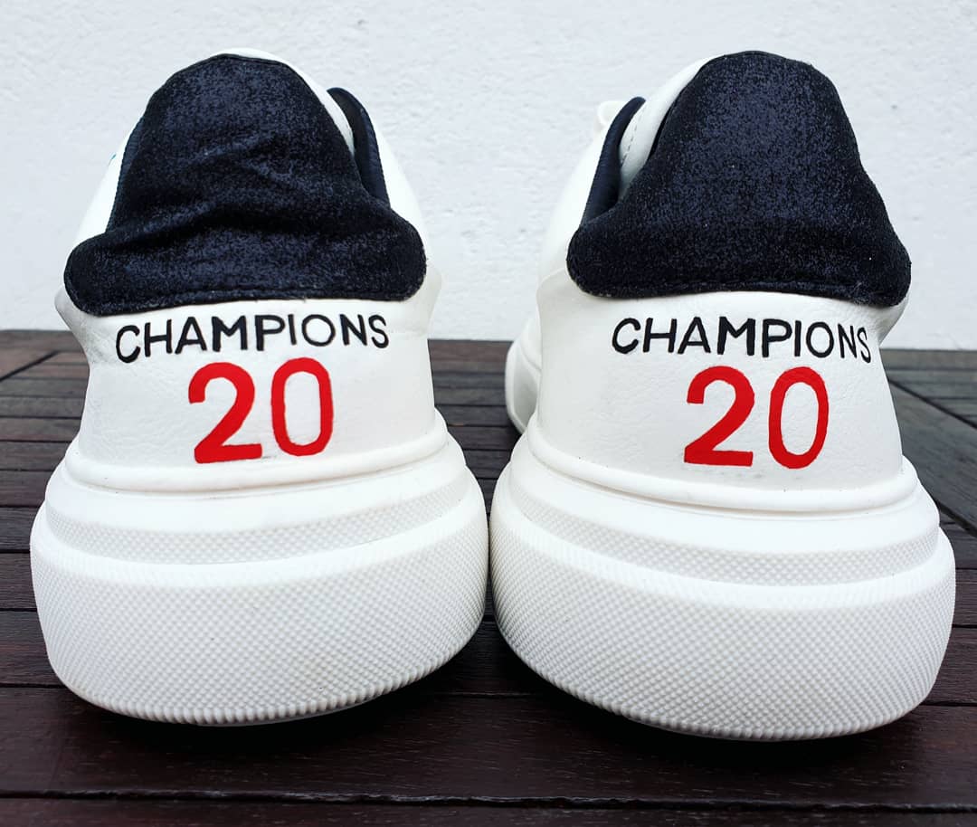 Custom Liverpool FC sneakers in white featuring hand-painted artwork with the club crest, Liverbird, “You’ll Never Walk Alone” slogan, and CHAMPIONS 20 detailing. Designed for Liverpool fans, these one-of-a-kind sneakers blend football passion with wearable art. Built on a durable white sole base with red and black accents, ideal for gifting or match day outfits.

