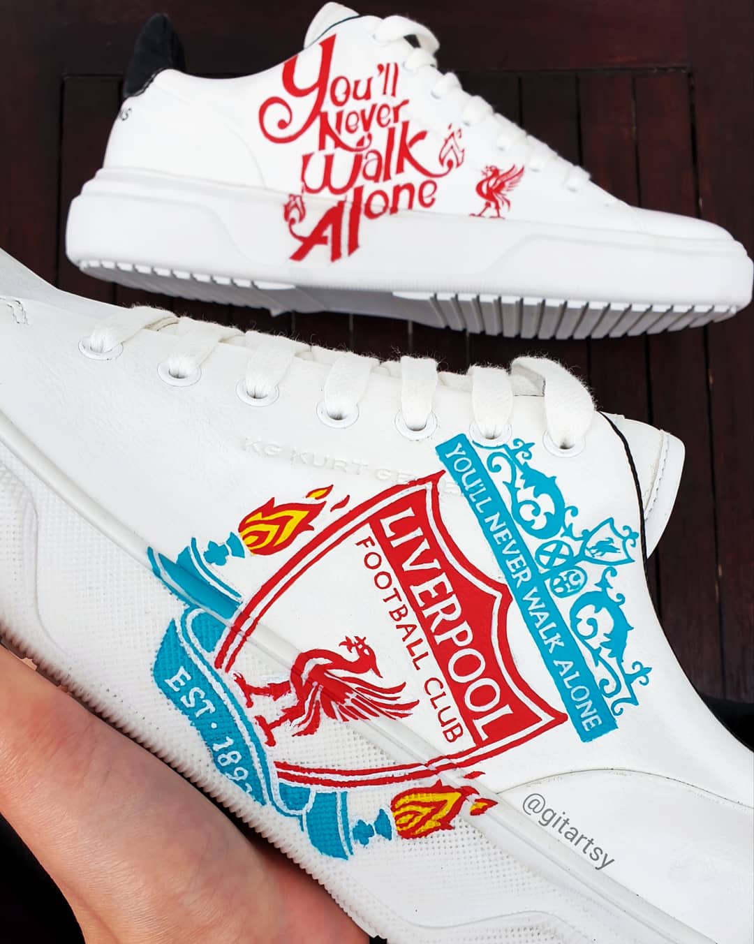 Custom Liverpool FC sneakers in white featuring hand-painted artwork with the club crest, Liverbird, “You’ll Never Walk Alone” slogan, and CHAMPIONS 20 detailing. Designed for Liverpool fans, these one-of-a-kind sneakers blend football passion with wearable art. Built on a durable white sole base with red and black accents, ideal for gifting or match day outfits.

