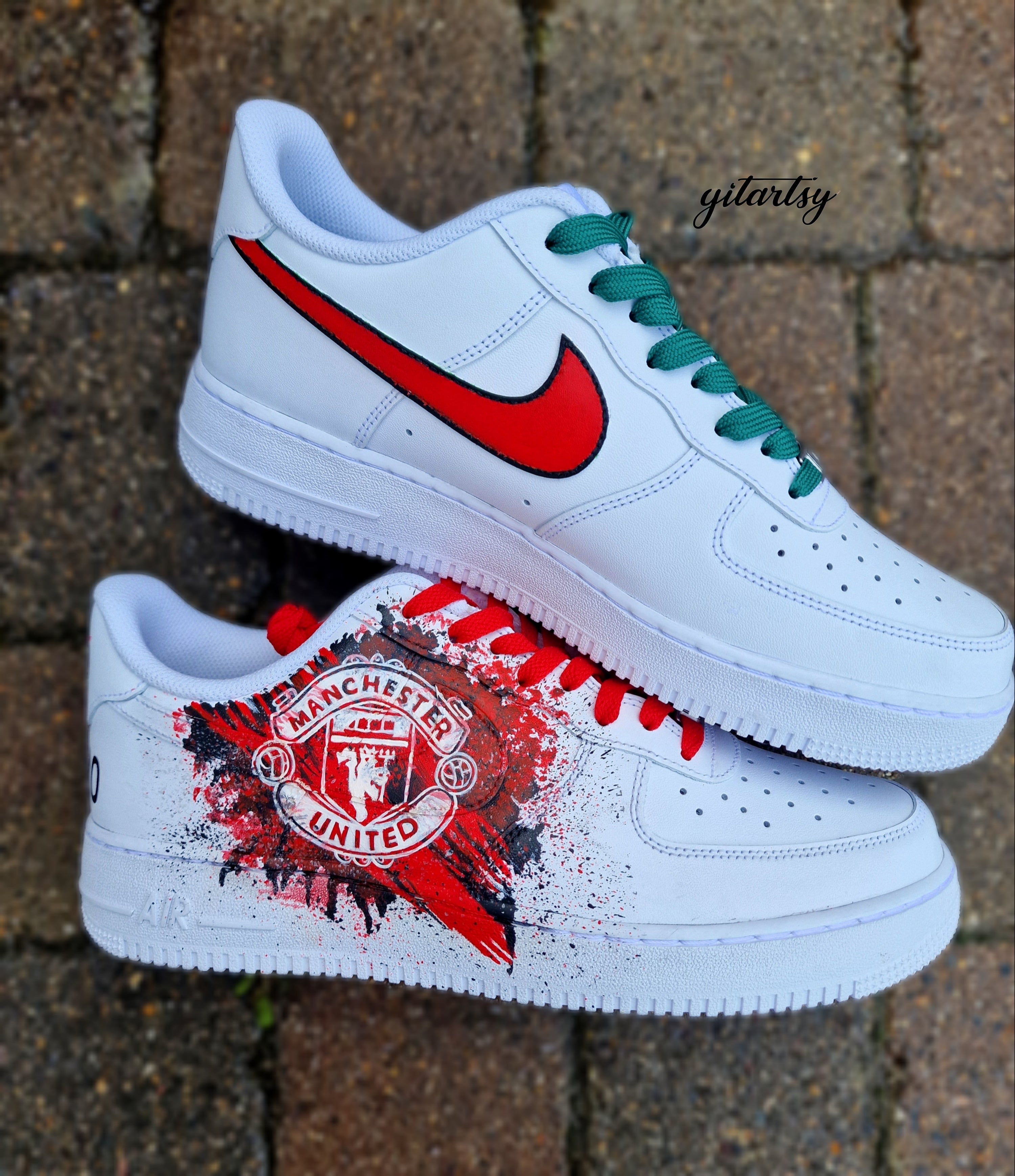 "Custom hand-painted Nike Air Force 1 sneakers featuring Manchester United and Portugal national football team crests, splattered in bold red, green, and black paint with unique details, crafted by Gitartsy."

