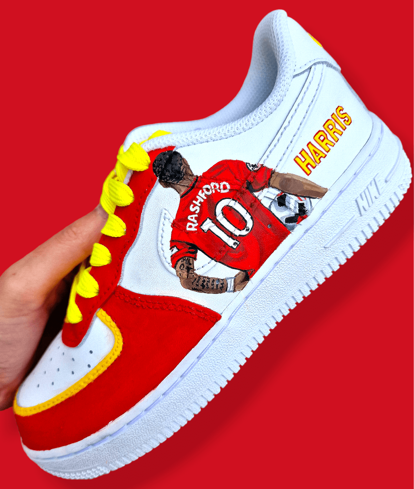Hand-painted custom sneakers featuring the Manchester United crest, Marcus Rashford kit illustration, and personalized details on a red, yellow, and white theme; perfect for football fans.


